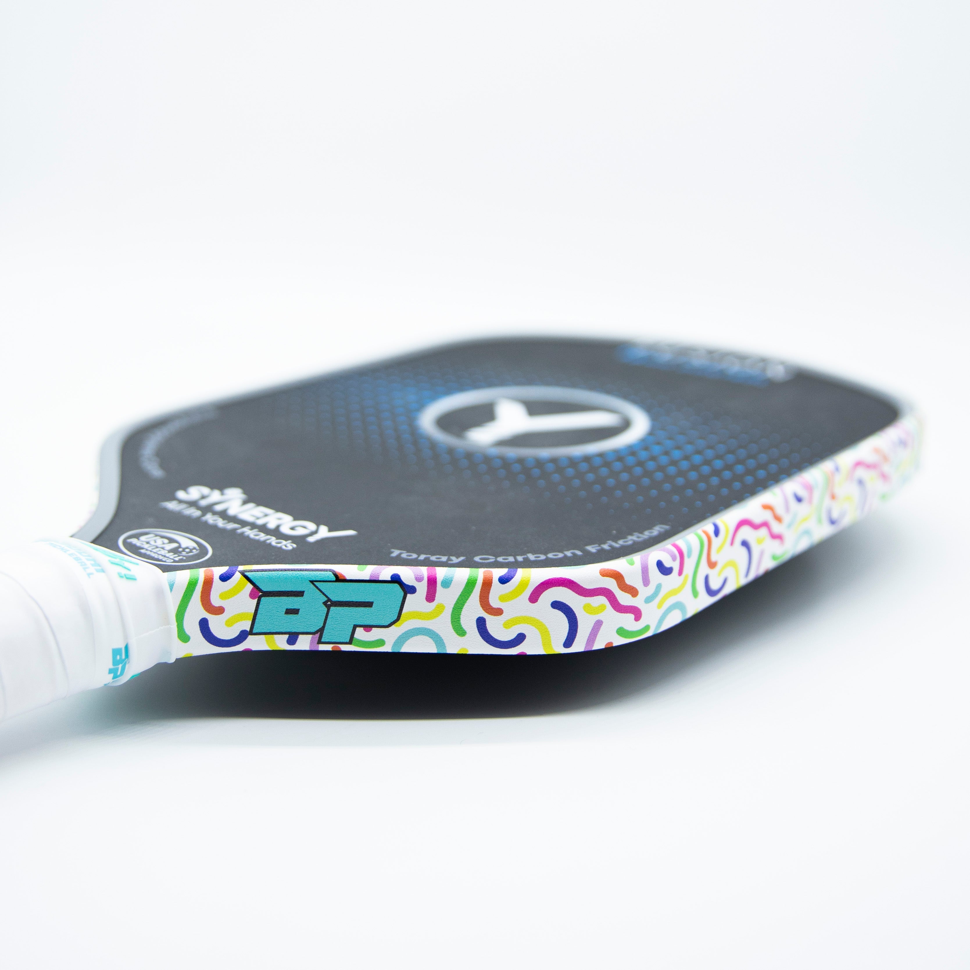 Close-up of a pickleball paddle with a colorful, patterned edge.