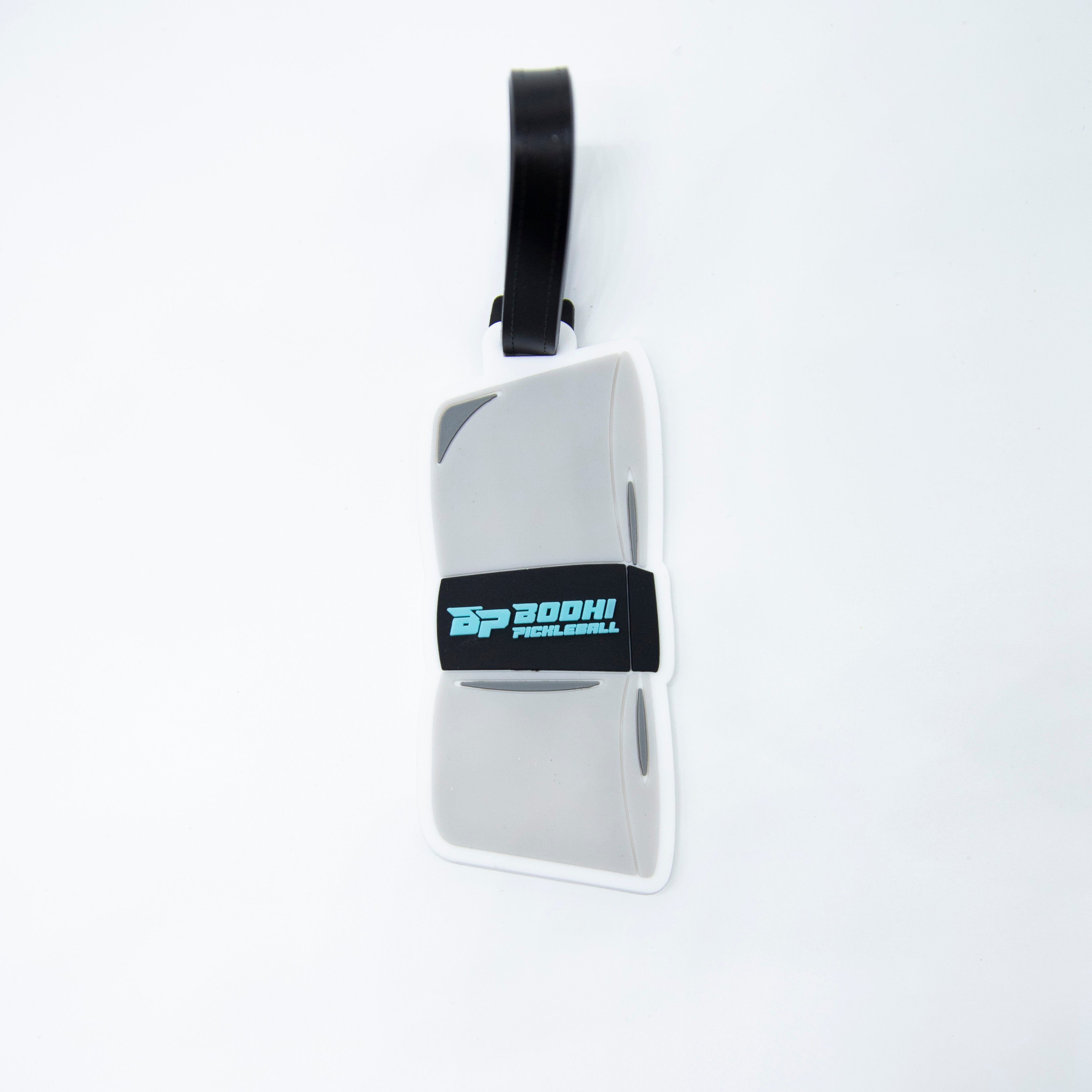 Gray pickleball paddle luggage tag with black strap and blue logo.