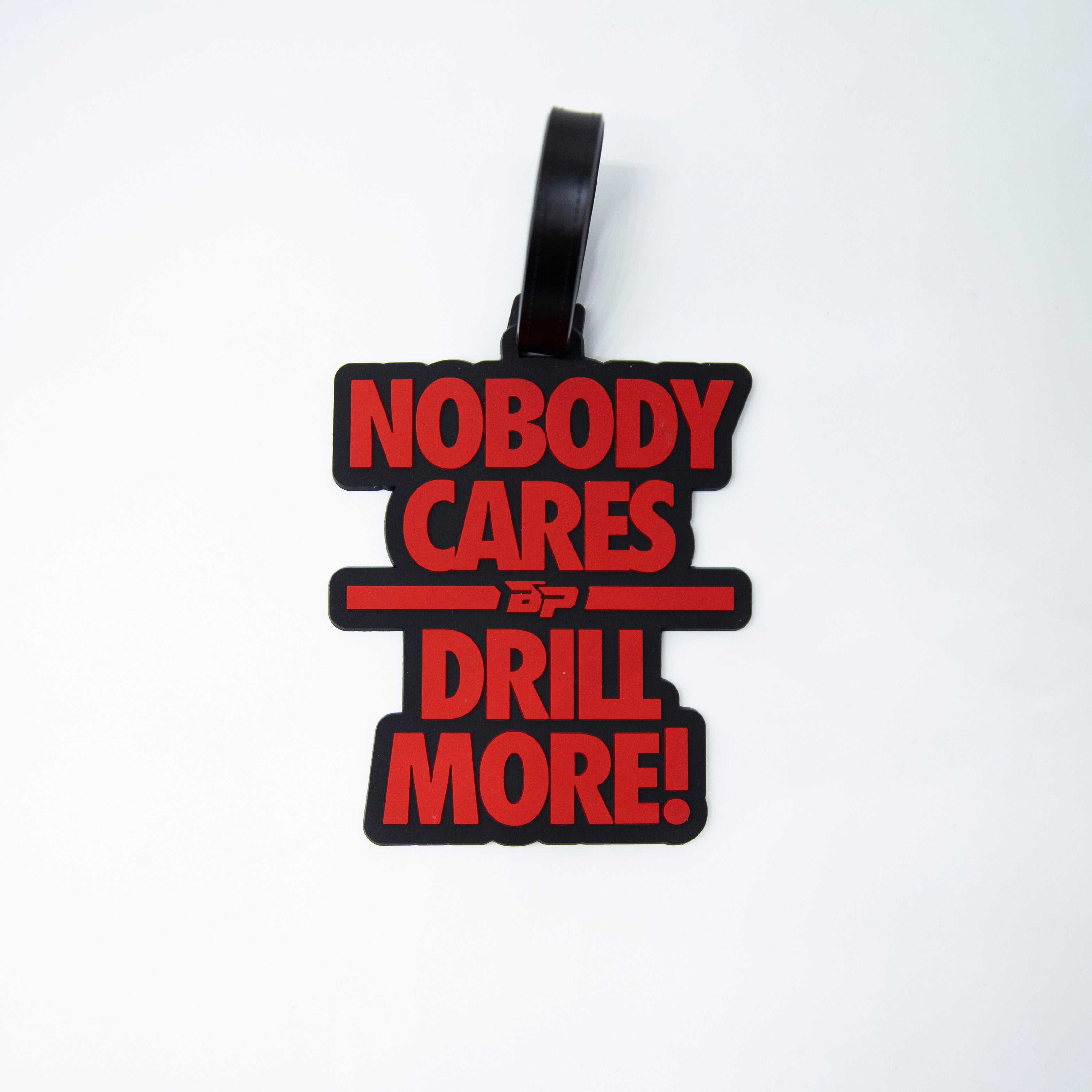 Black and red luggage tag that says "Nobody Cares Drill More!"