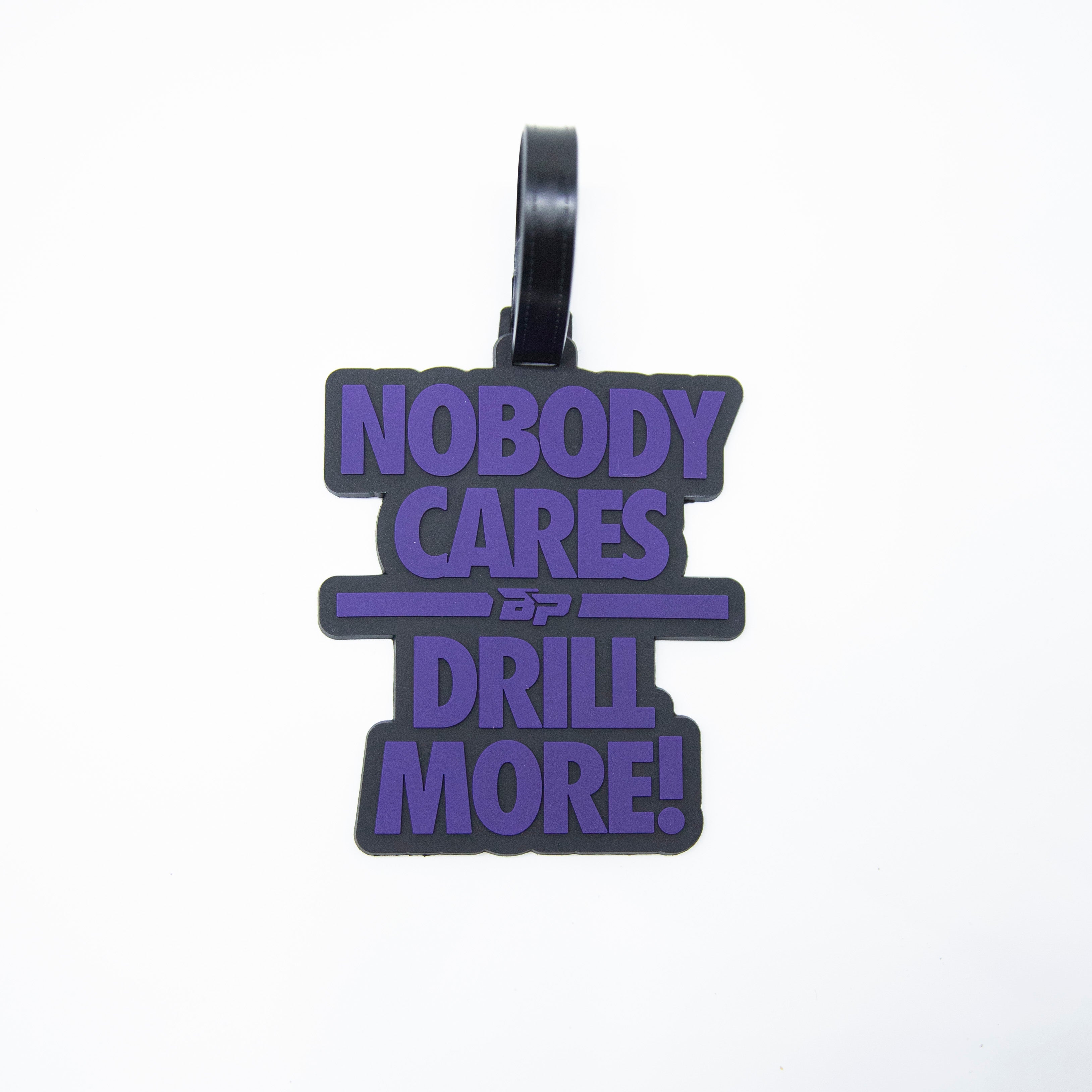 Black and purple luggage tag that says "Nobody Cares. Drill More!".