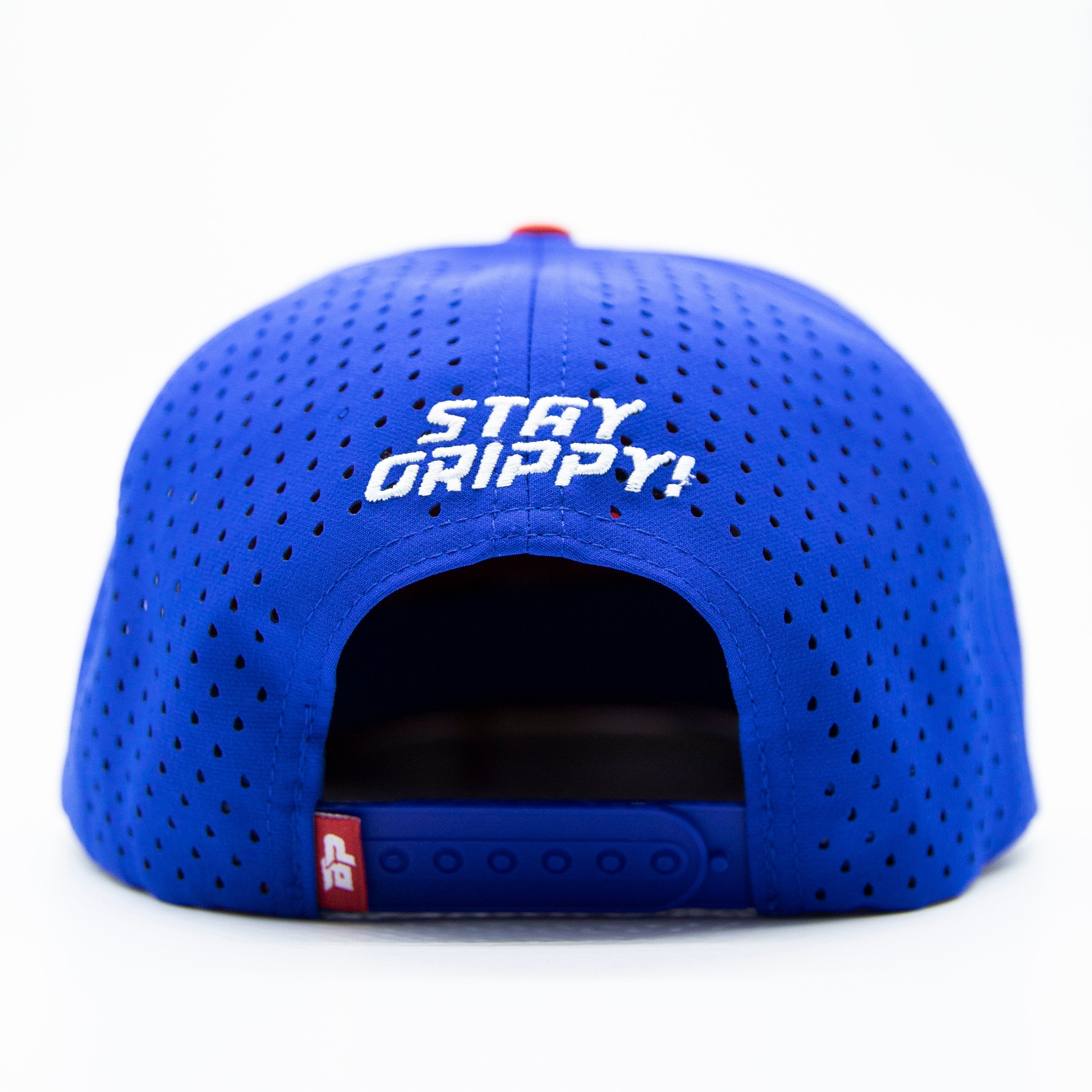 Back of a blue perforated baseball cap with white embroidered text that reads "STAY GRIPPY!" on a white background.