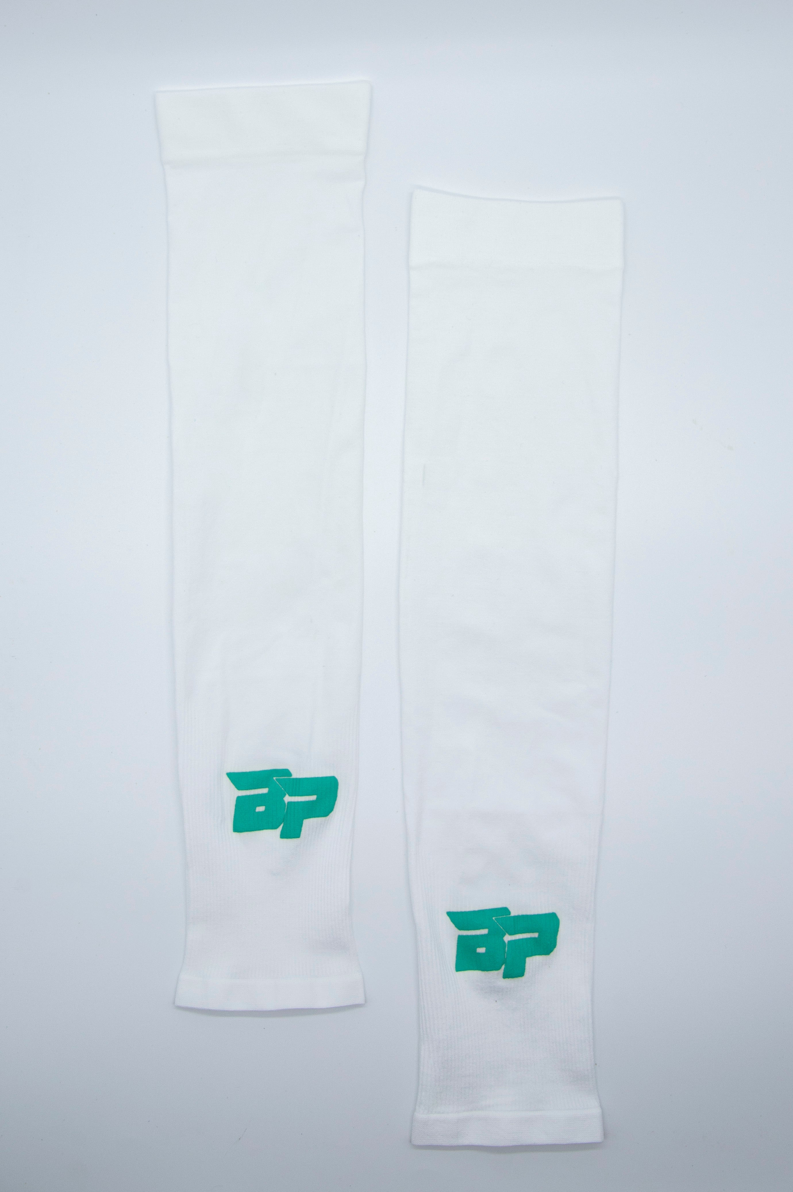 Two white athletic arm sleeves with green logos.