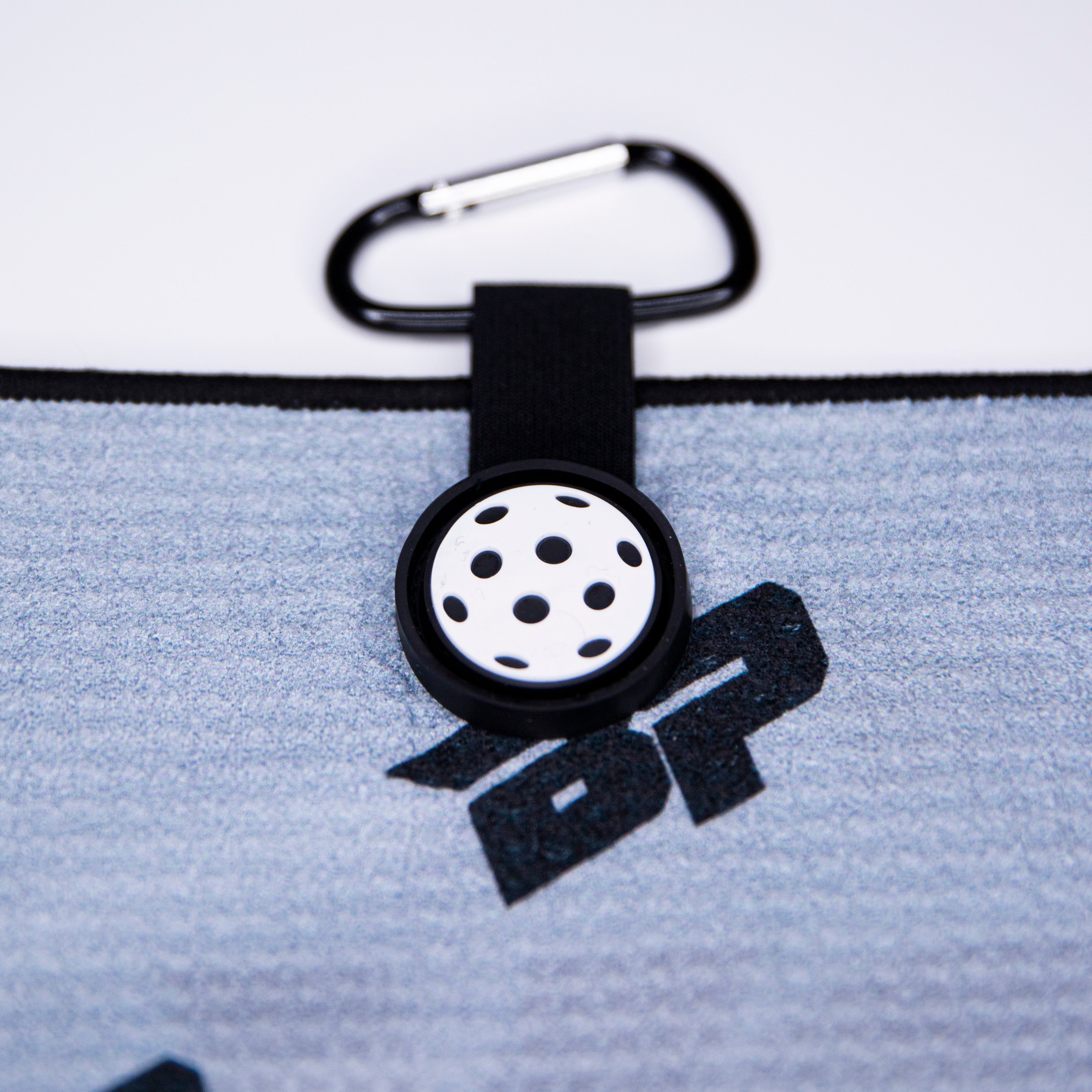 Gray pickleball towel with black logo, attachment loop, and carabiner.