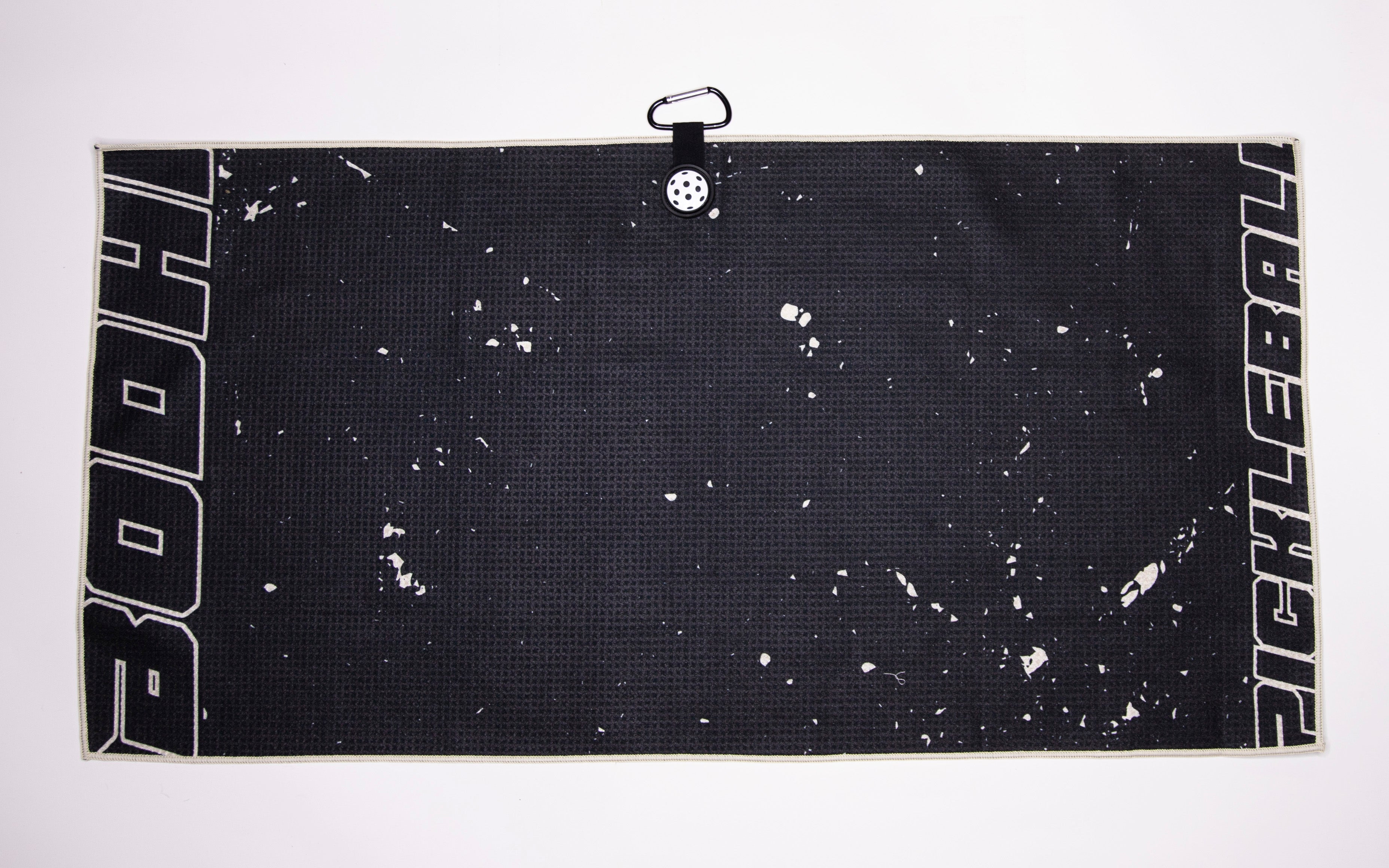 A black pickleball towel with white text and a clip.
