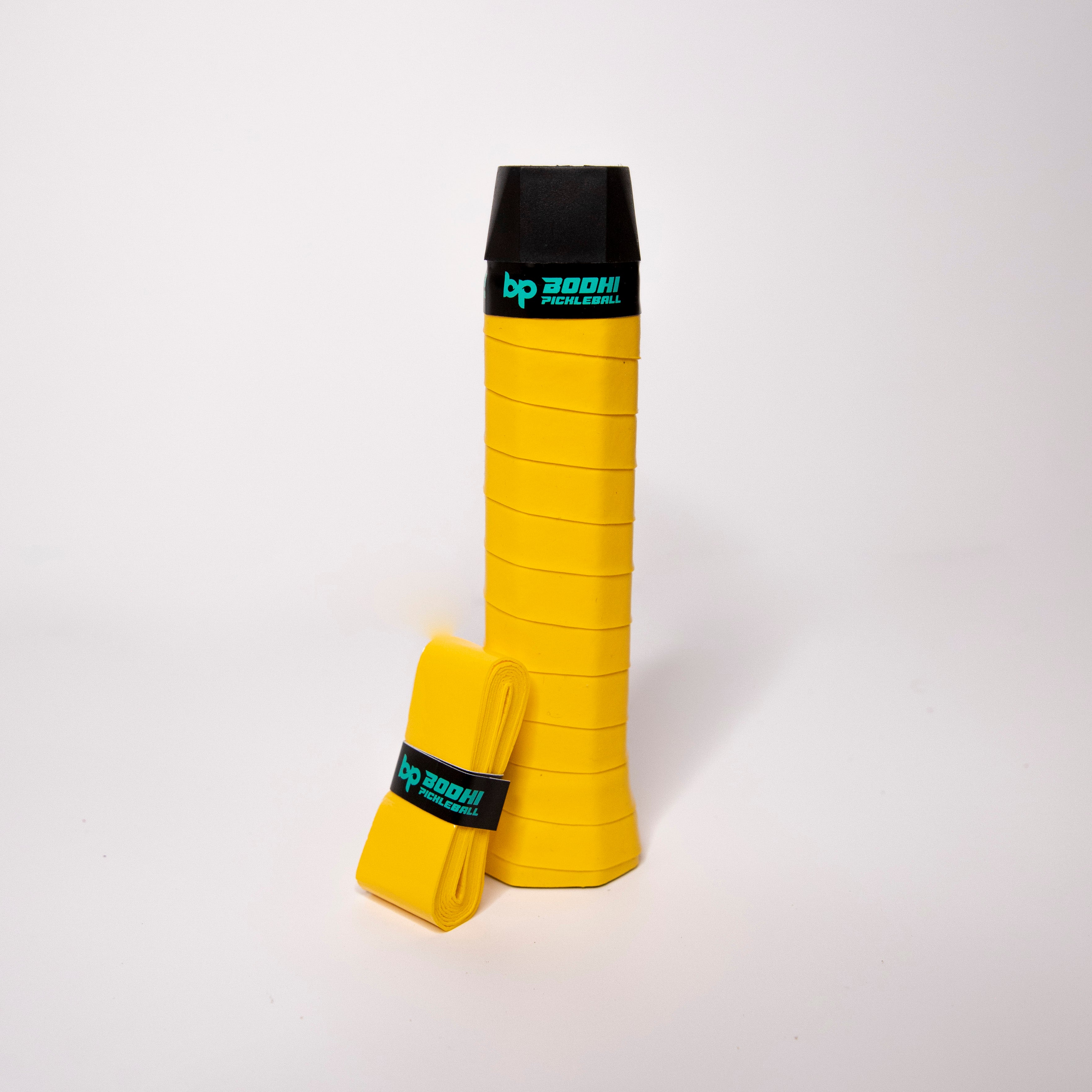 Yellow pickleball paddle grip with a black cap. Wrapped yellow grip.