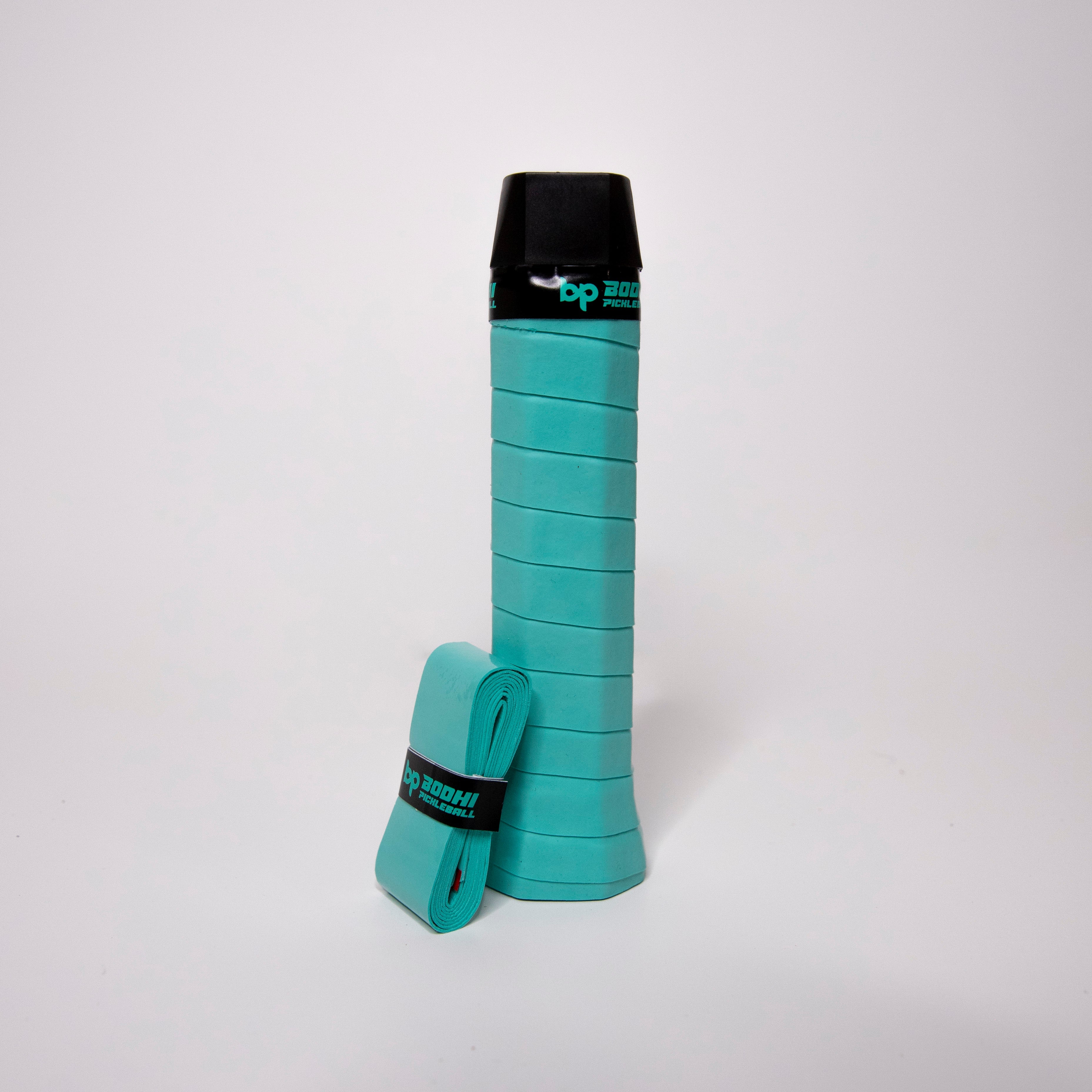 Turquoise grip on a black handled pickleball paddle with a wrapped grip.