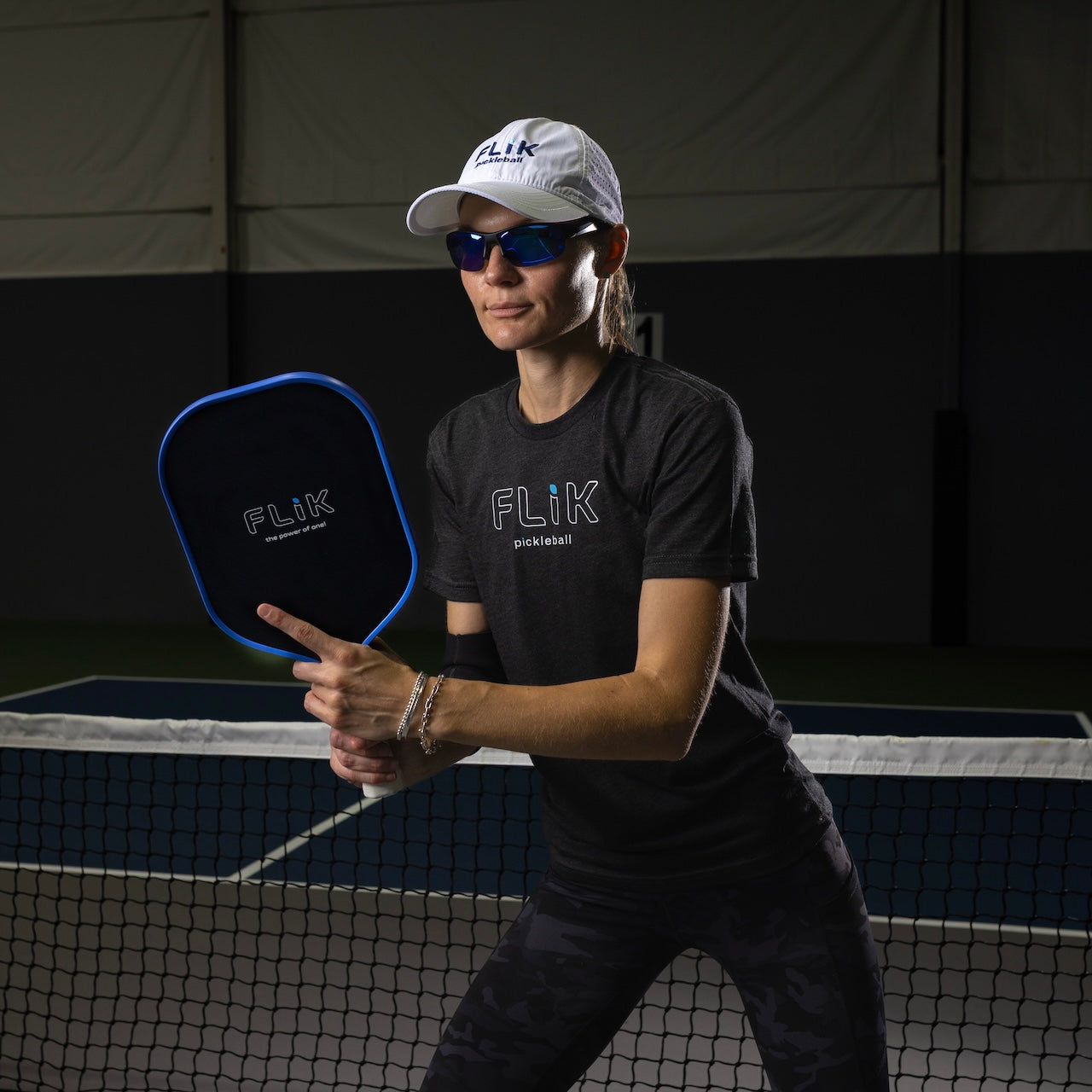 Woman in workout gear holding a pickleball racket.