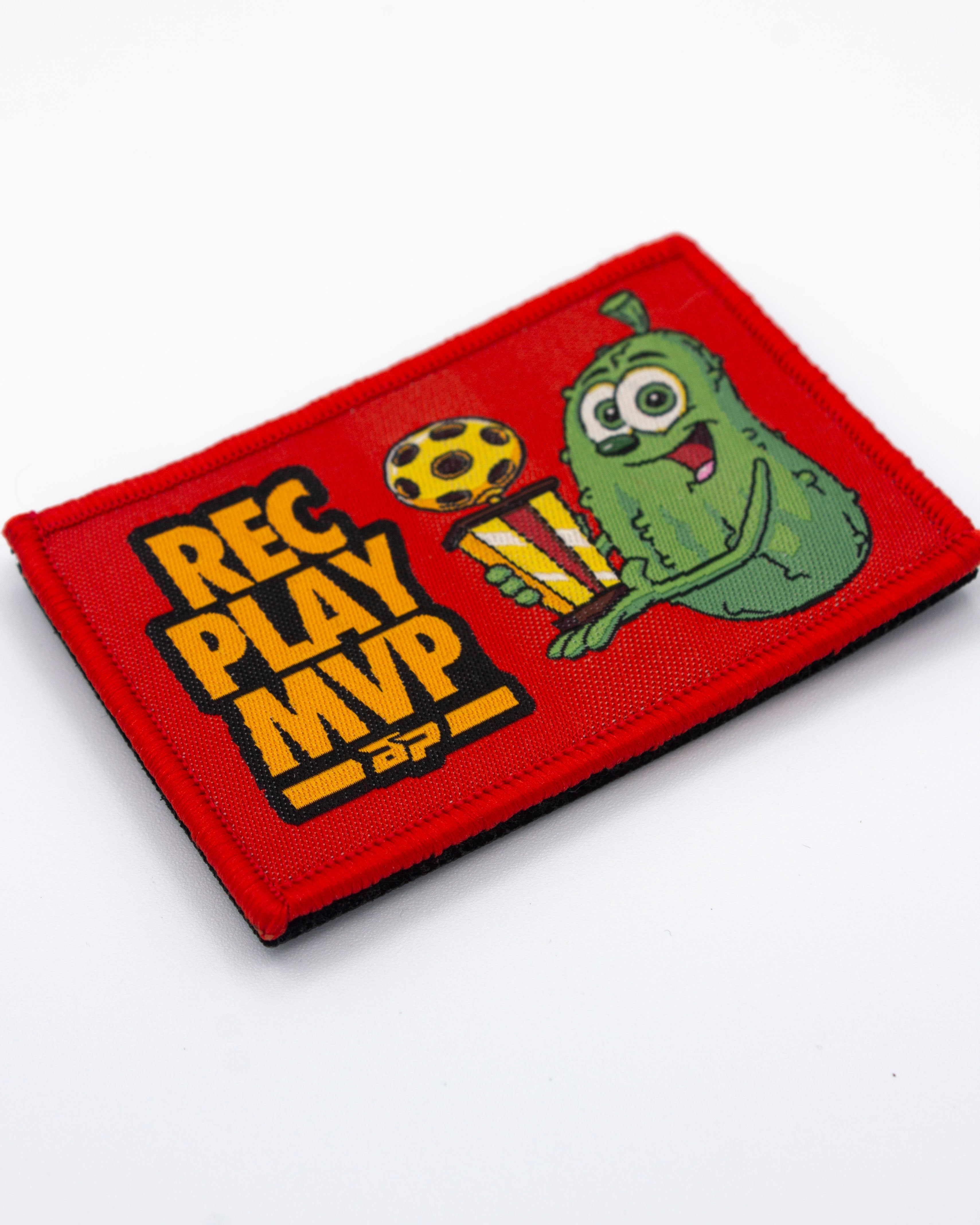 Red rectangular woven Velcro patch by Bodhi Performance, with a green pickle character holding a striped trophy, a yellow soccer ball, and 'REC PLAY MVP' text.