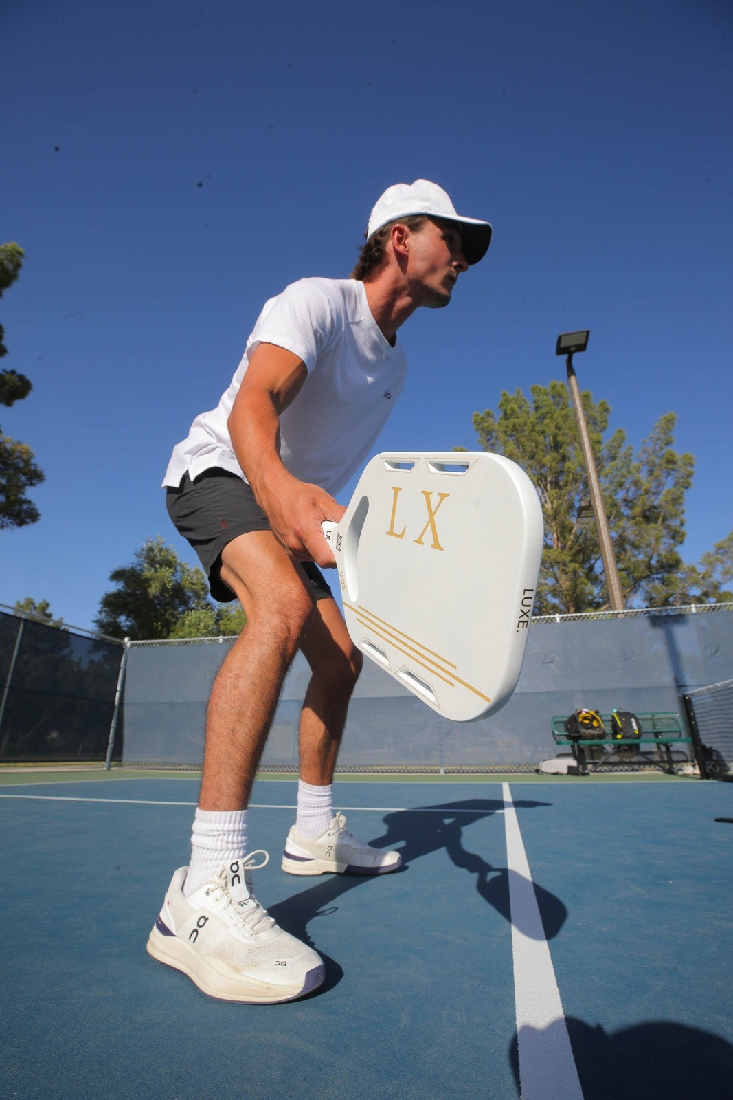 Man in athletic wear holding pickleball paddle on court.