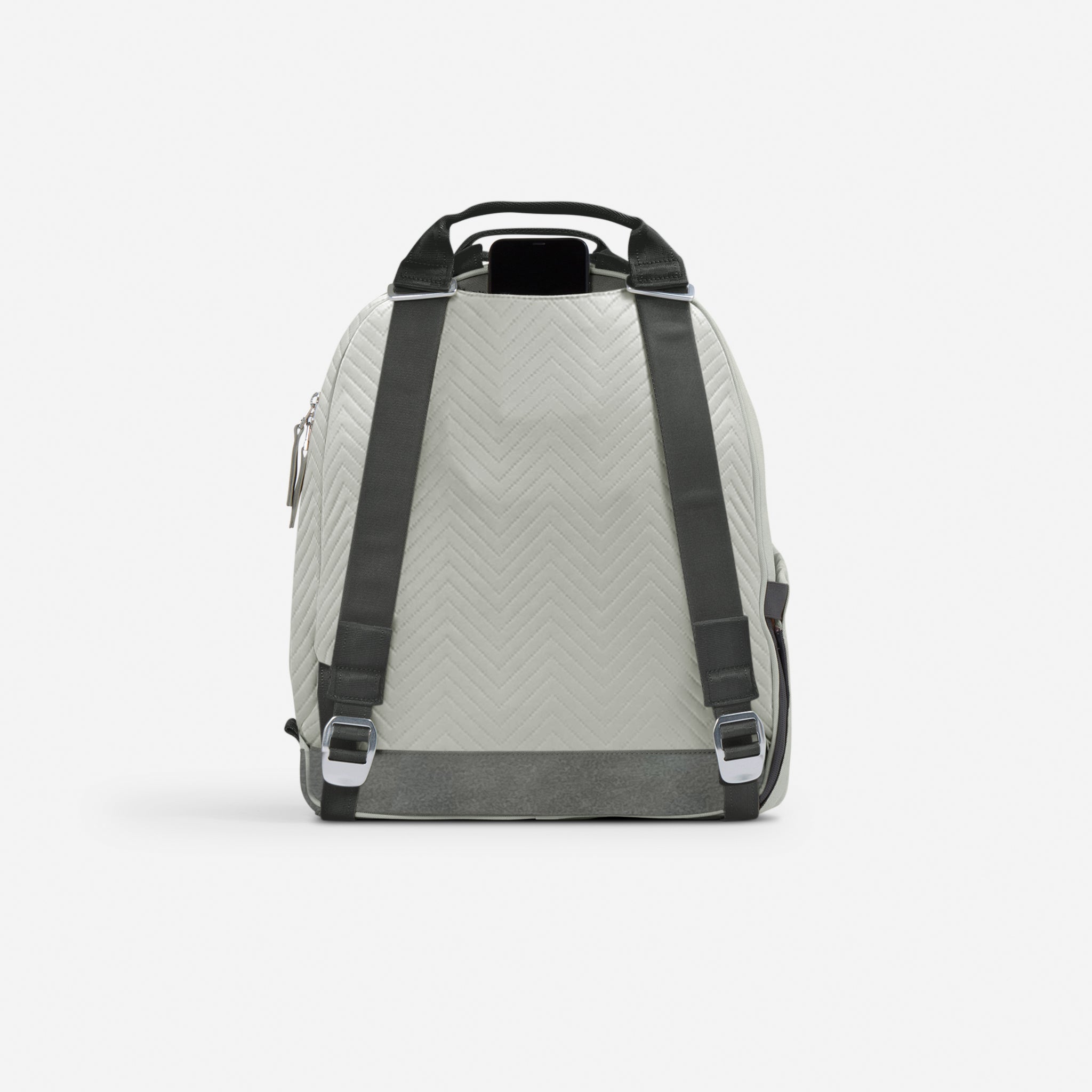 Quilted light grey tennis backpack by Doubletake with chevron pattern, dark straps, and a phone, back view.