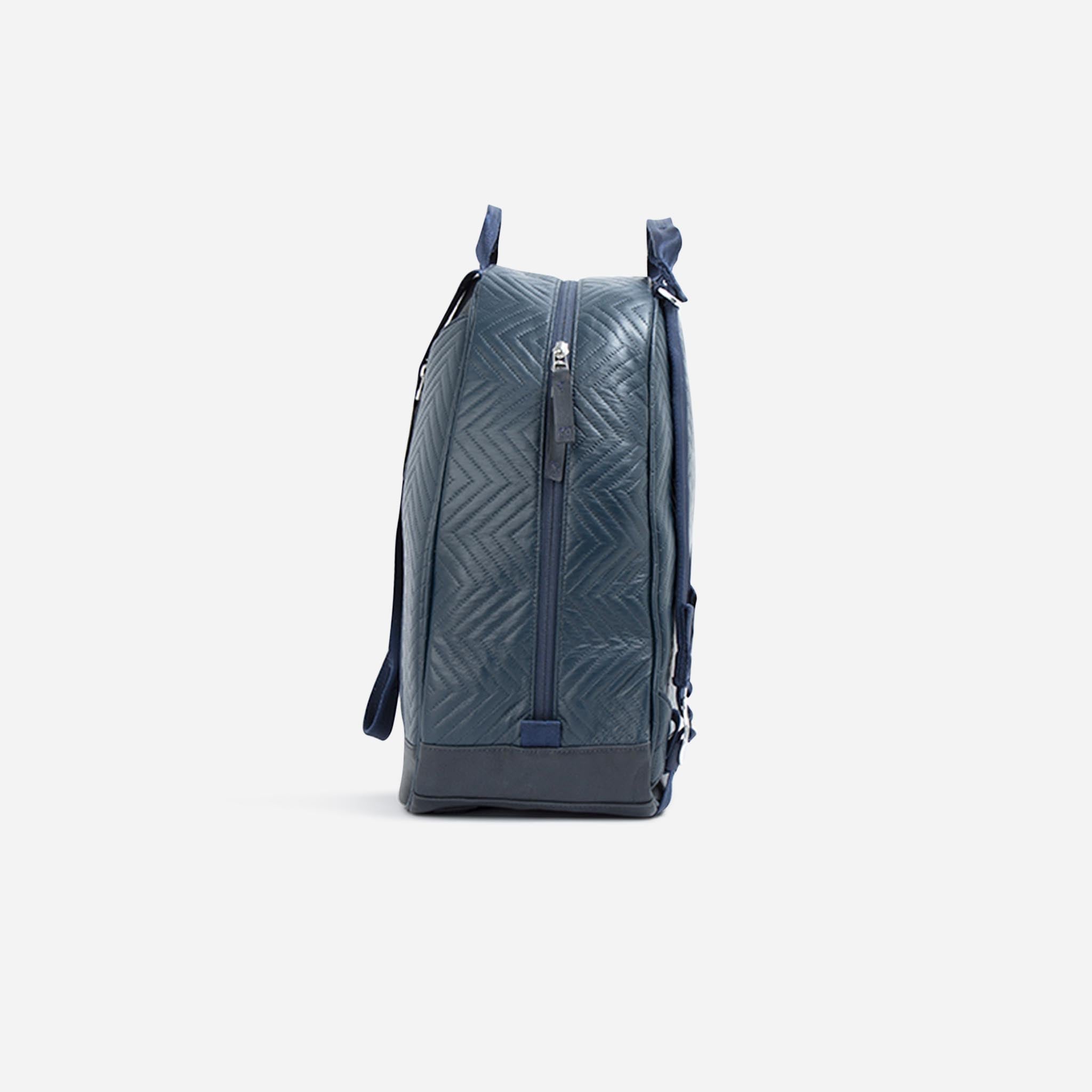 Navy blue quilted tennis backpack by Doubletake, with a chevron pattern and side zipper, shown in a side view.