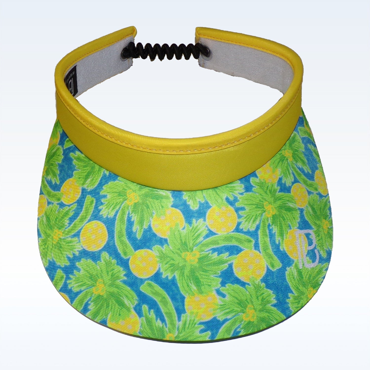 Yellow brim visor by Pickleball Bella with a blue, green, and yellow pickleball and palm tree pattern, a white 'PB' logo, and a black coiled adjustable strap.