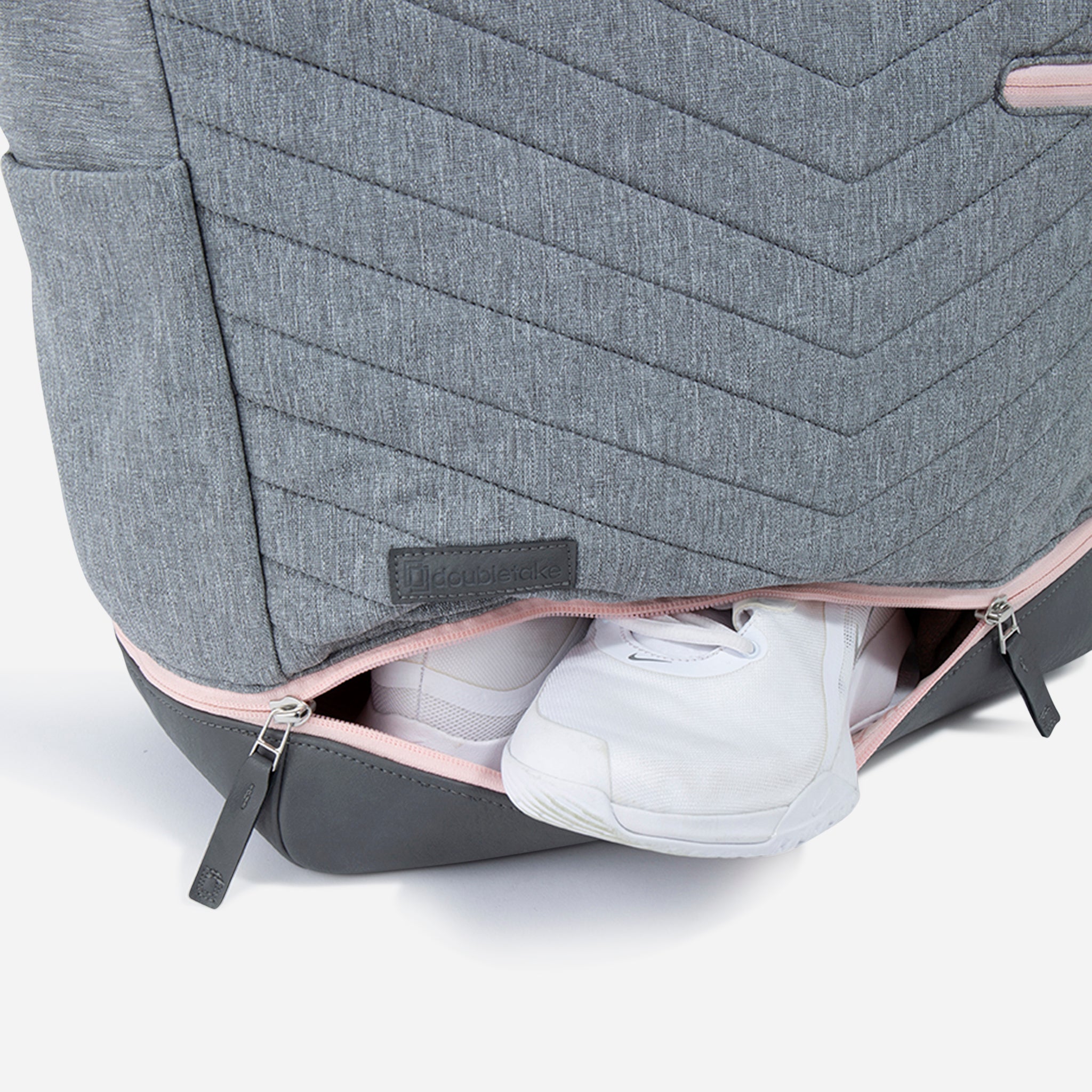 Grey quilted Tennis Tote by Doubletake with a pink zipper revealing white sneakers in the bottom compartment.