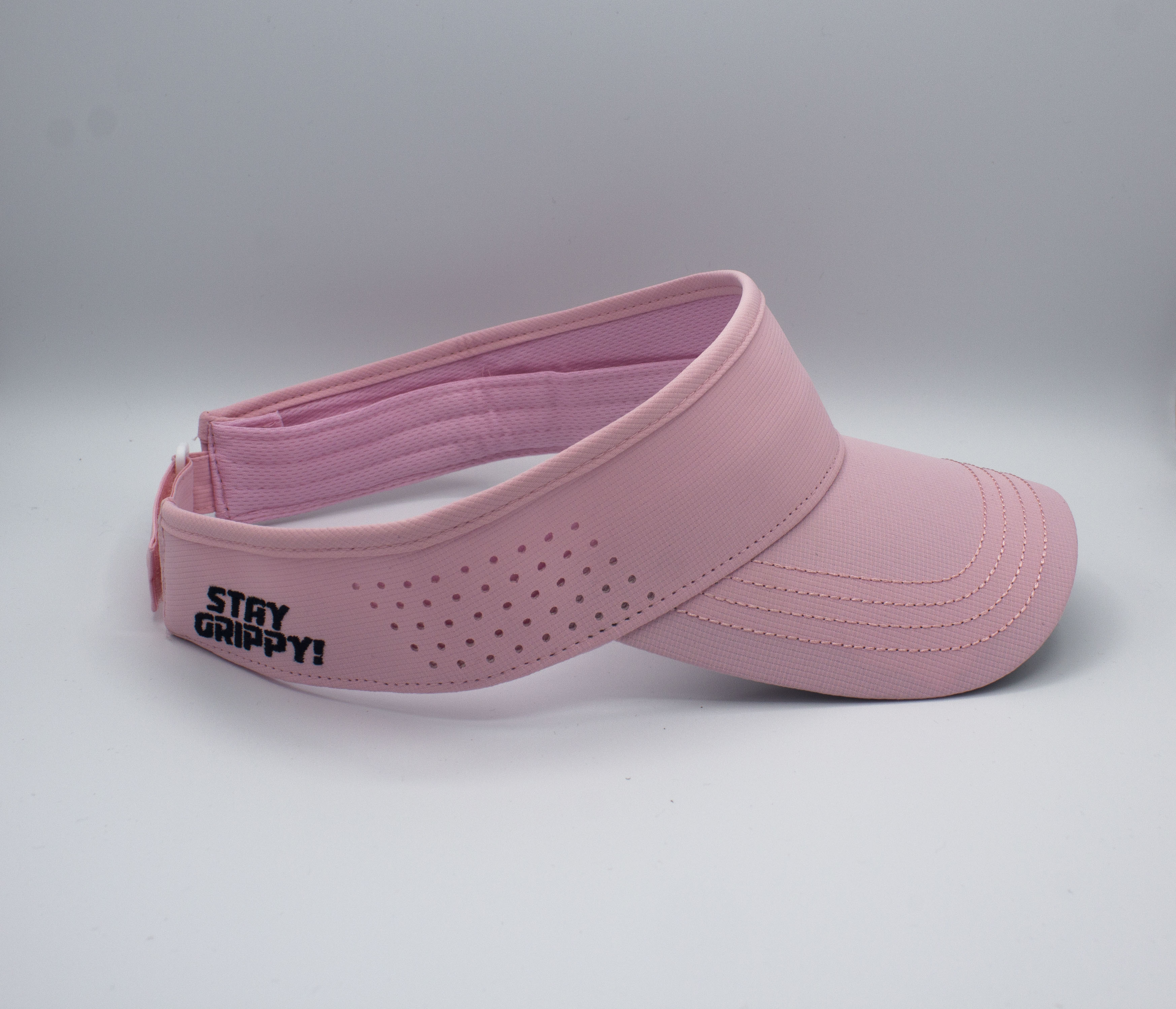Pink sun visor with "STAY GRIPPY!" text.