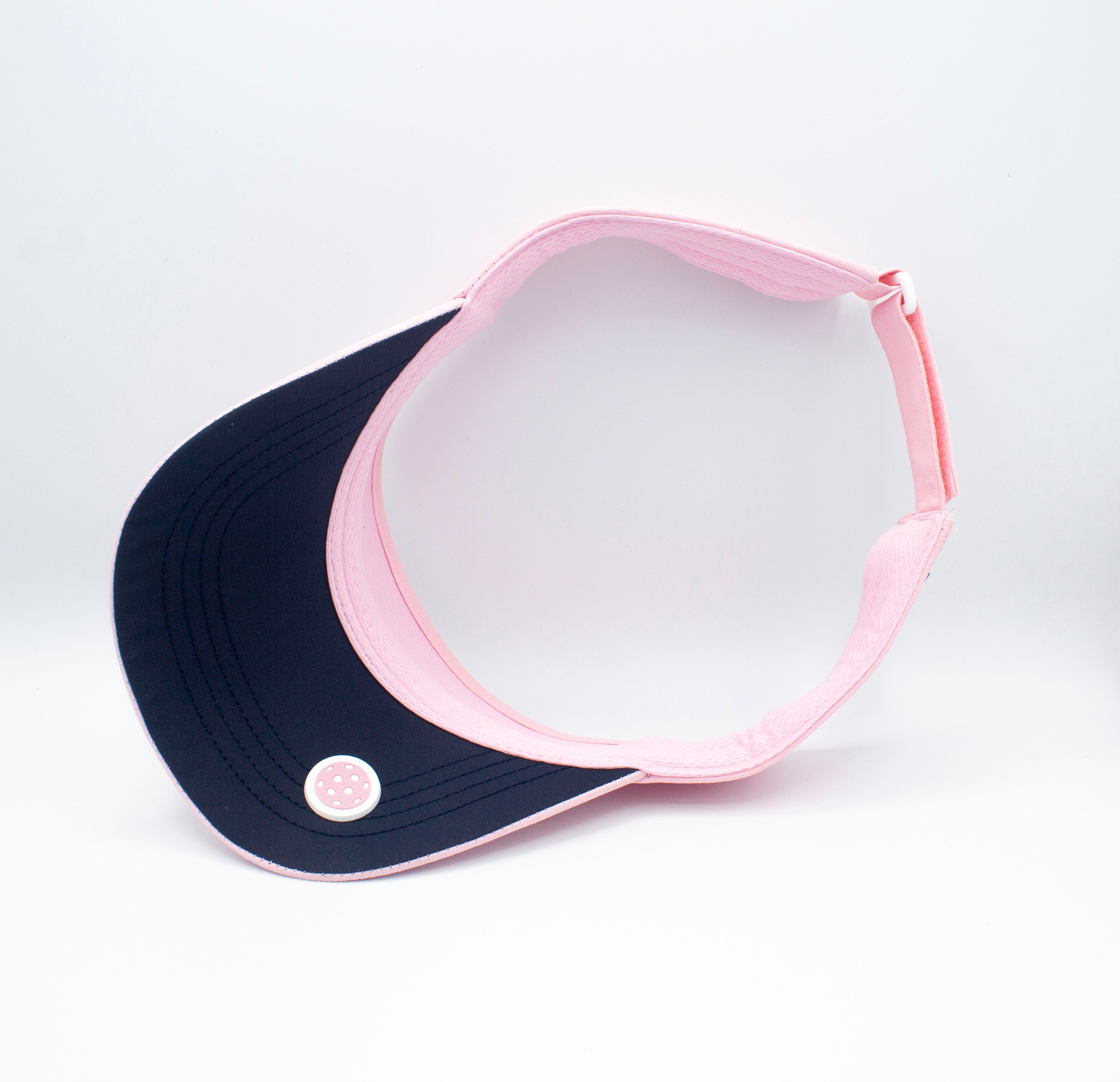Pink visor, navy brim, and polka dot accent.