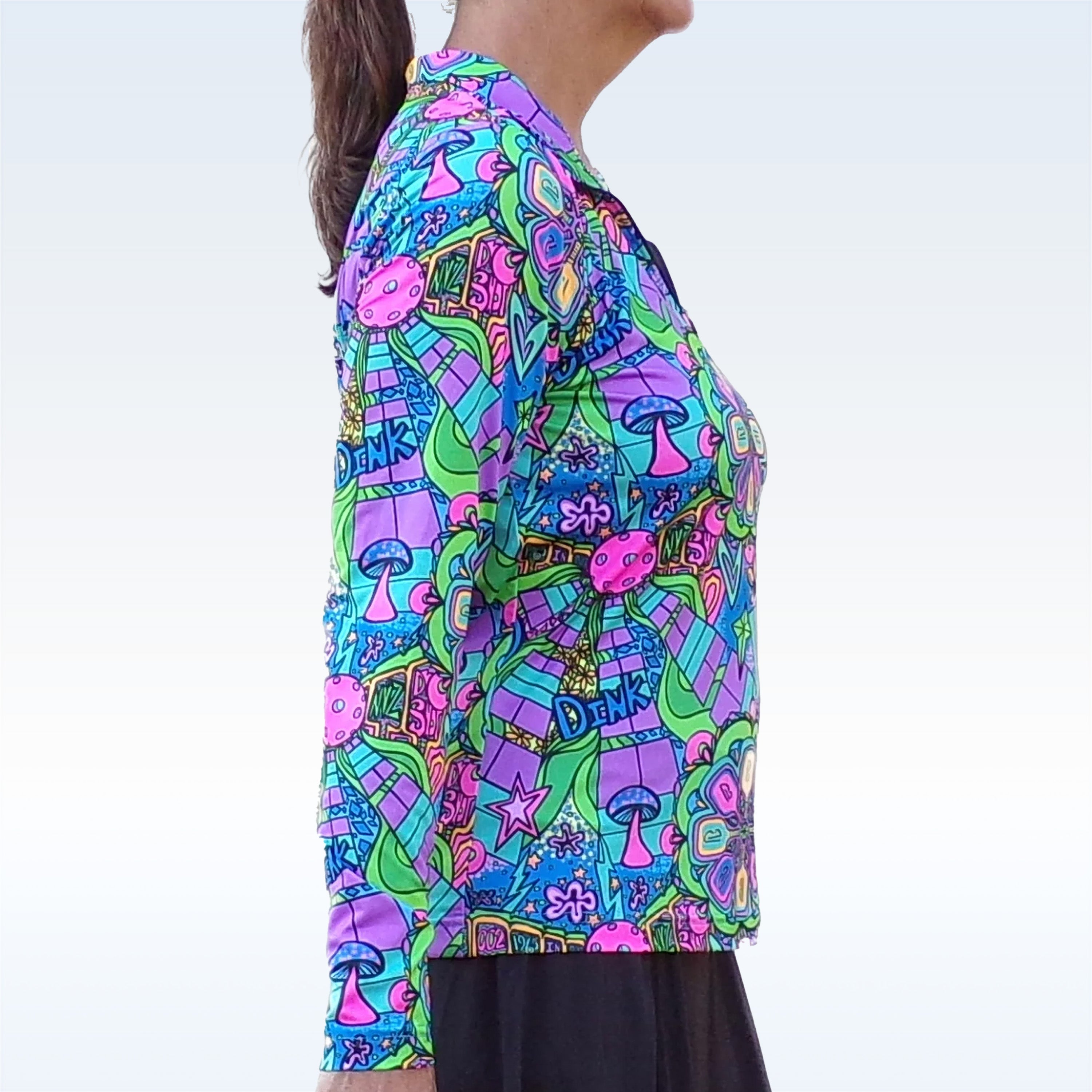 Groovy 1/4 Zip Long Sleeve Pullover by Pickleball Bella, with vibrant mushrooms and stars pattern, paired with a black skirt, side view.