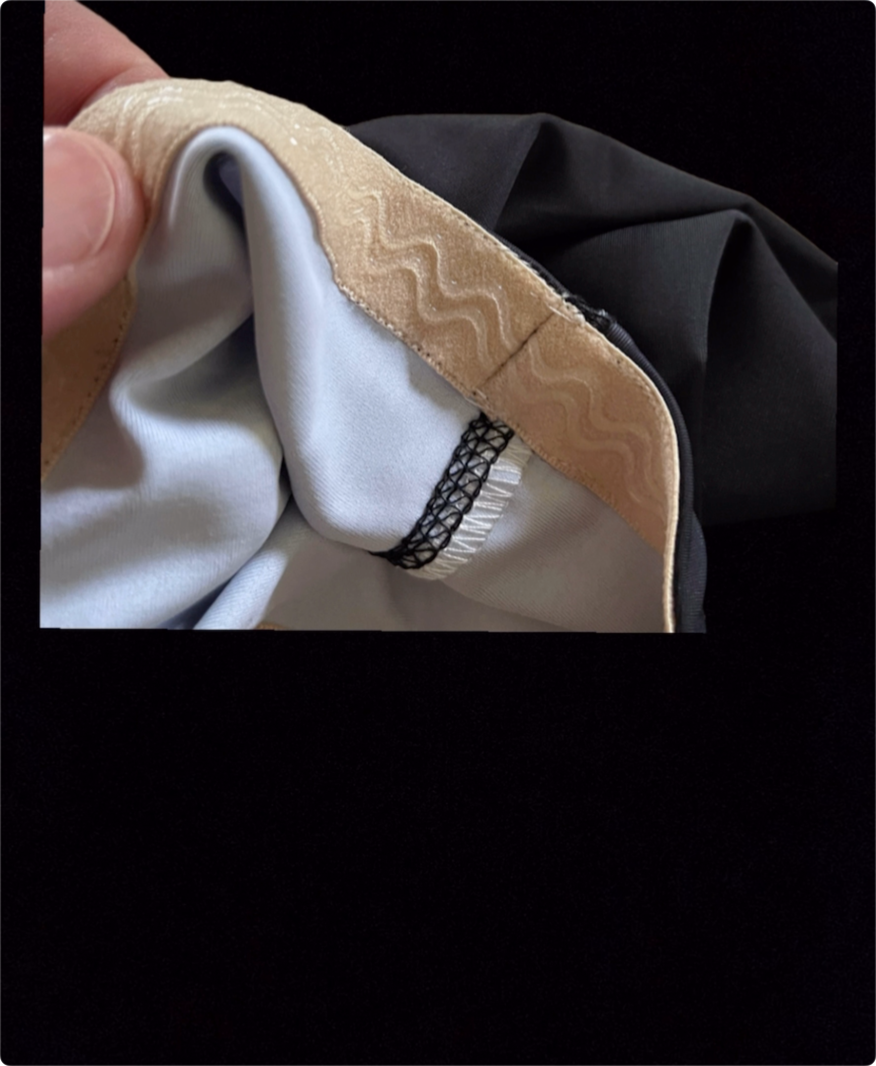 Close-up of garment with beige, wavy-patterned trim.