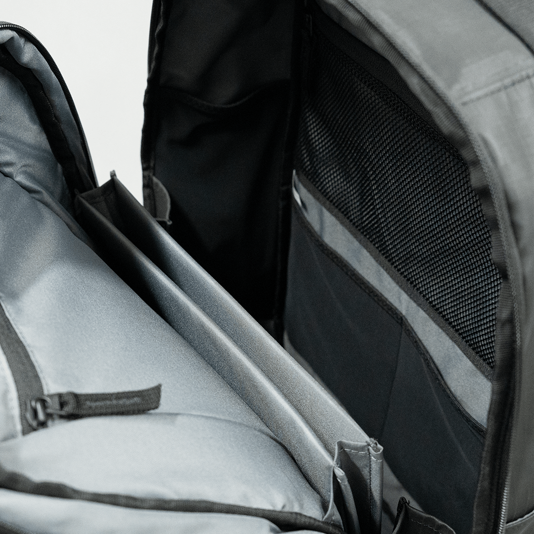 Grey interior pickleball backpack by FORWRD with padded compartments, a mesh pocket, and various organizers.