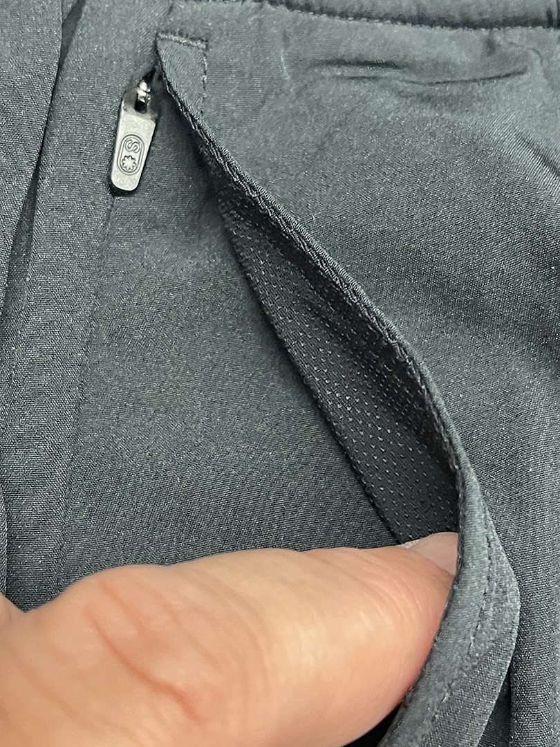 Close-up of gray athletic pants with a zippered pocket.