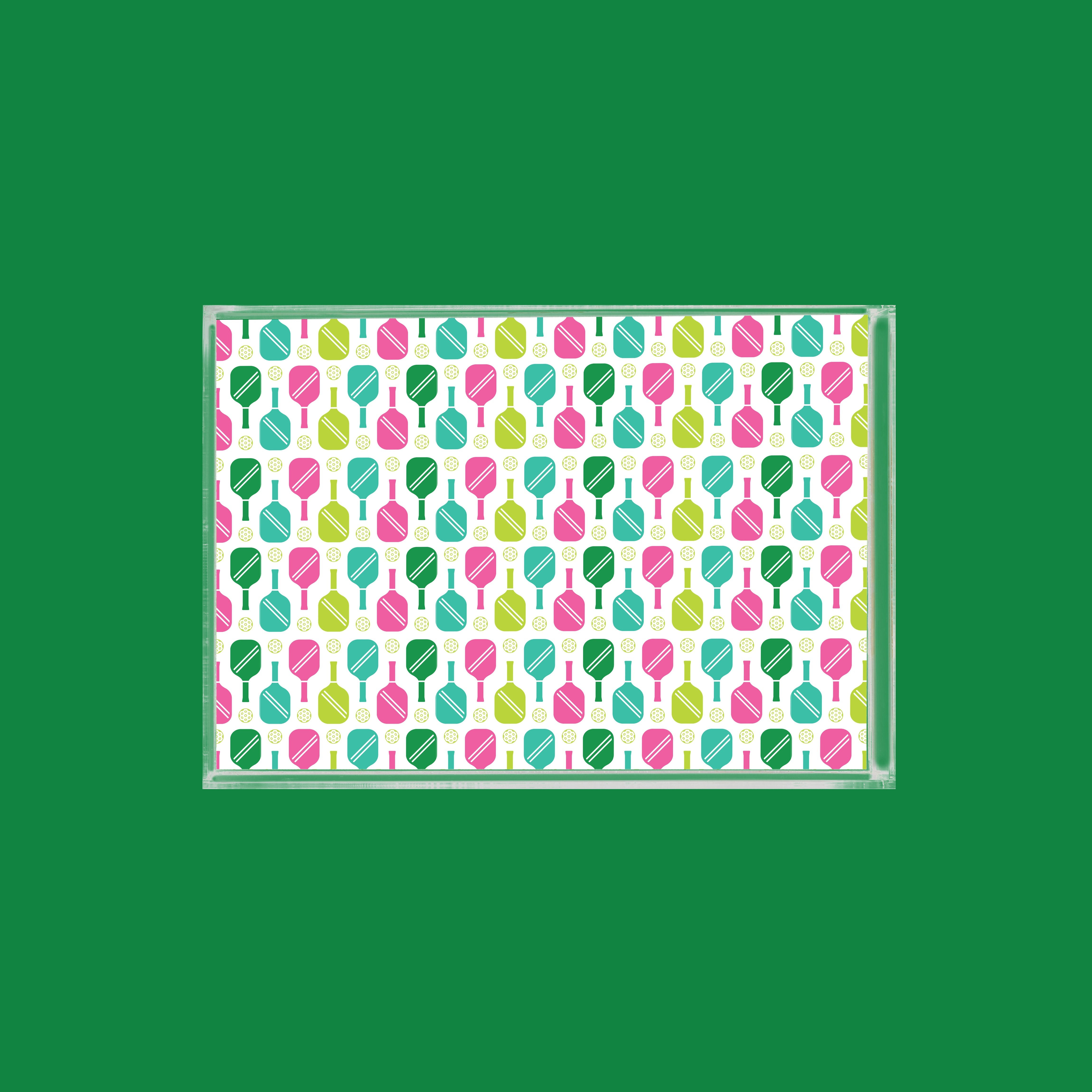 Clear box filled with colorful paddle and ball pattern. Green background.