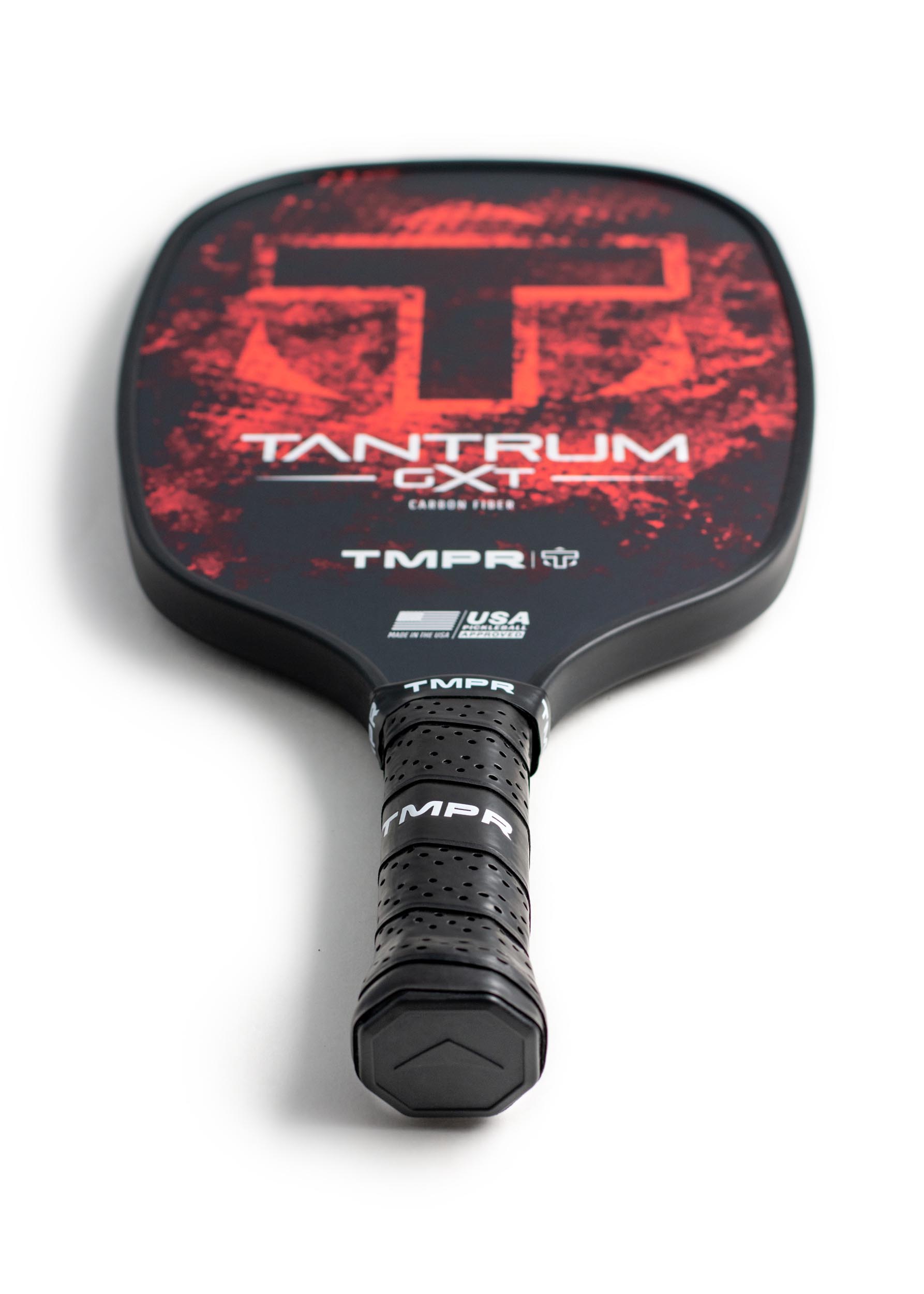 Black and red pickleball paddle by TMPR Sports, with a distressed red graphic and prominent "T" logo, featuring a textured black grip.