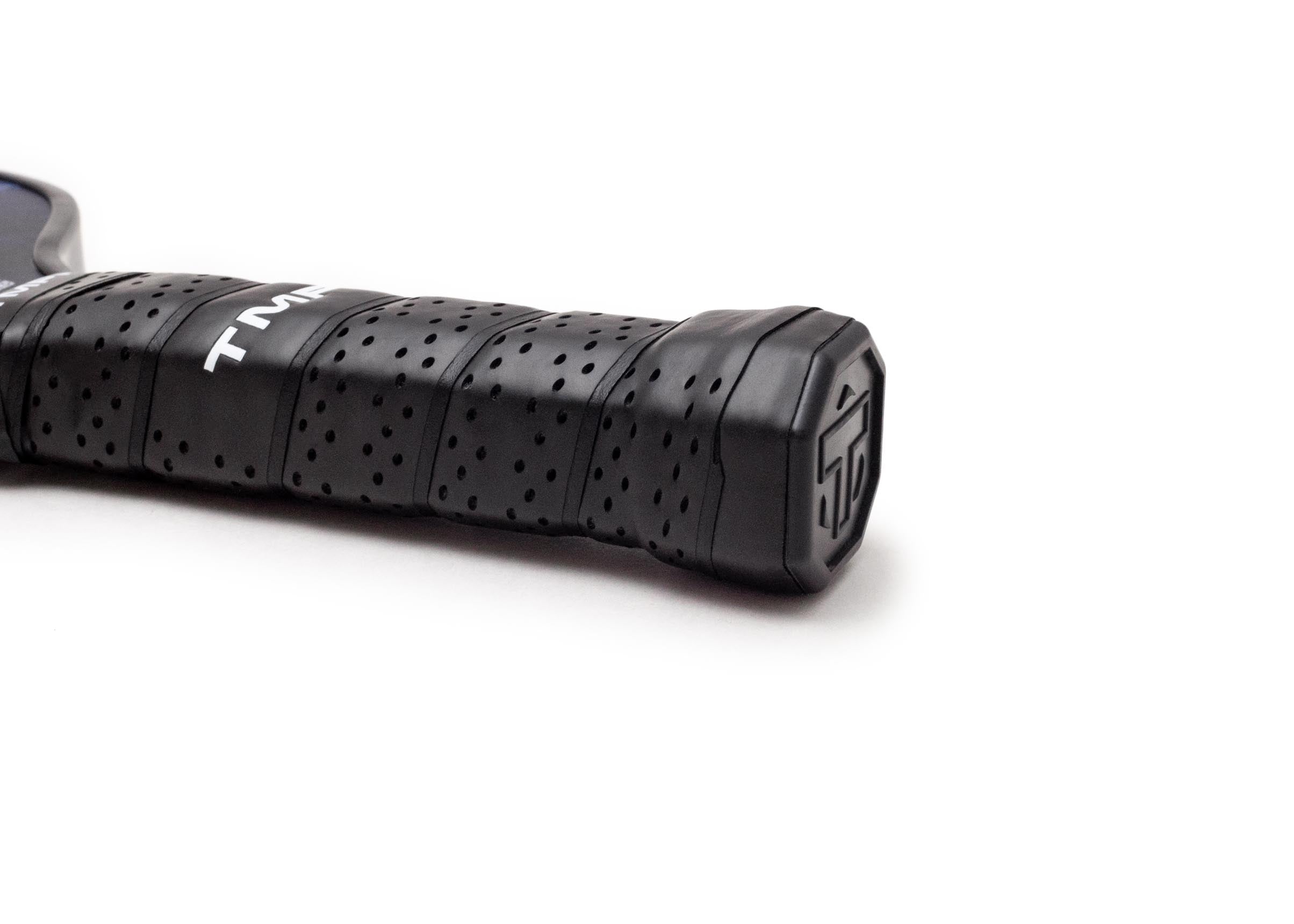 Black perforated pickleball paddle grip by TMPR Sports with white "TM" logos and an embossed end cap.
