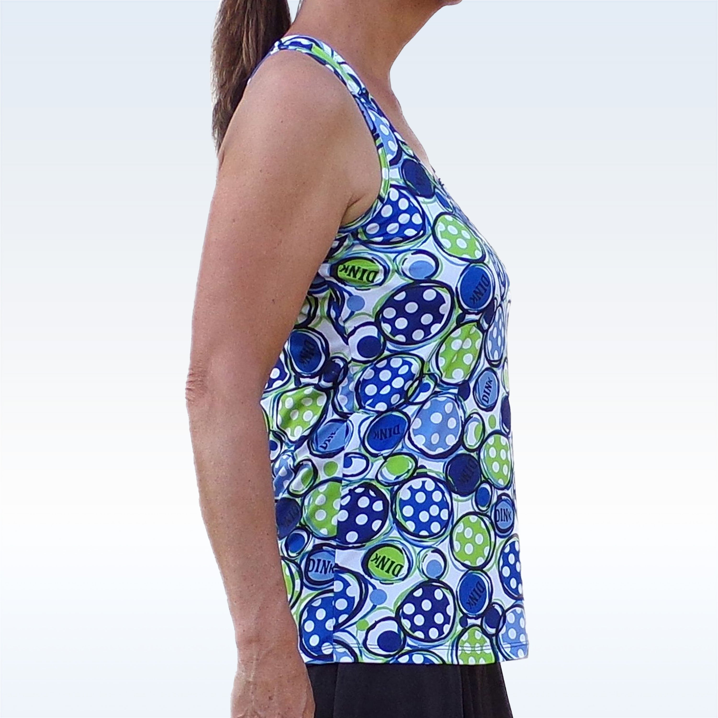 Blue, green, and white patterned racerback tank by Pickleball Bella, featuring polka dots and "DINK" text, worn by a model from the side.