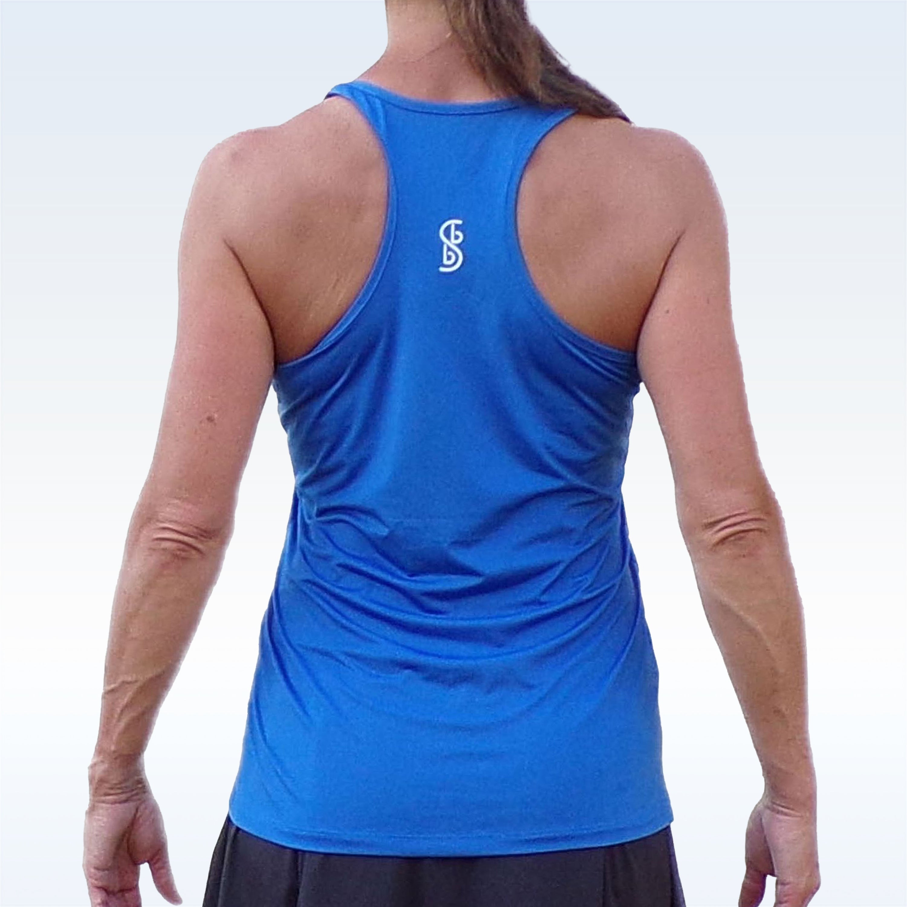 Royal Blue Racerback Tank by Pickleball Bella with a white stacked 'SB' logo on the upper back, worn by a woman with a dark skirt.