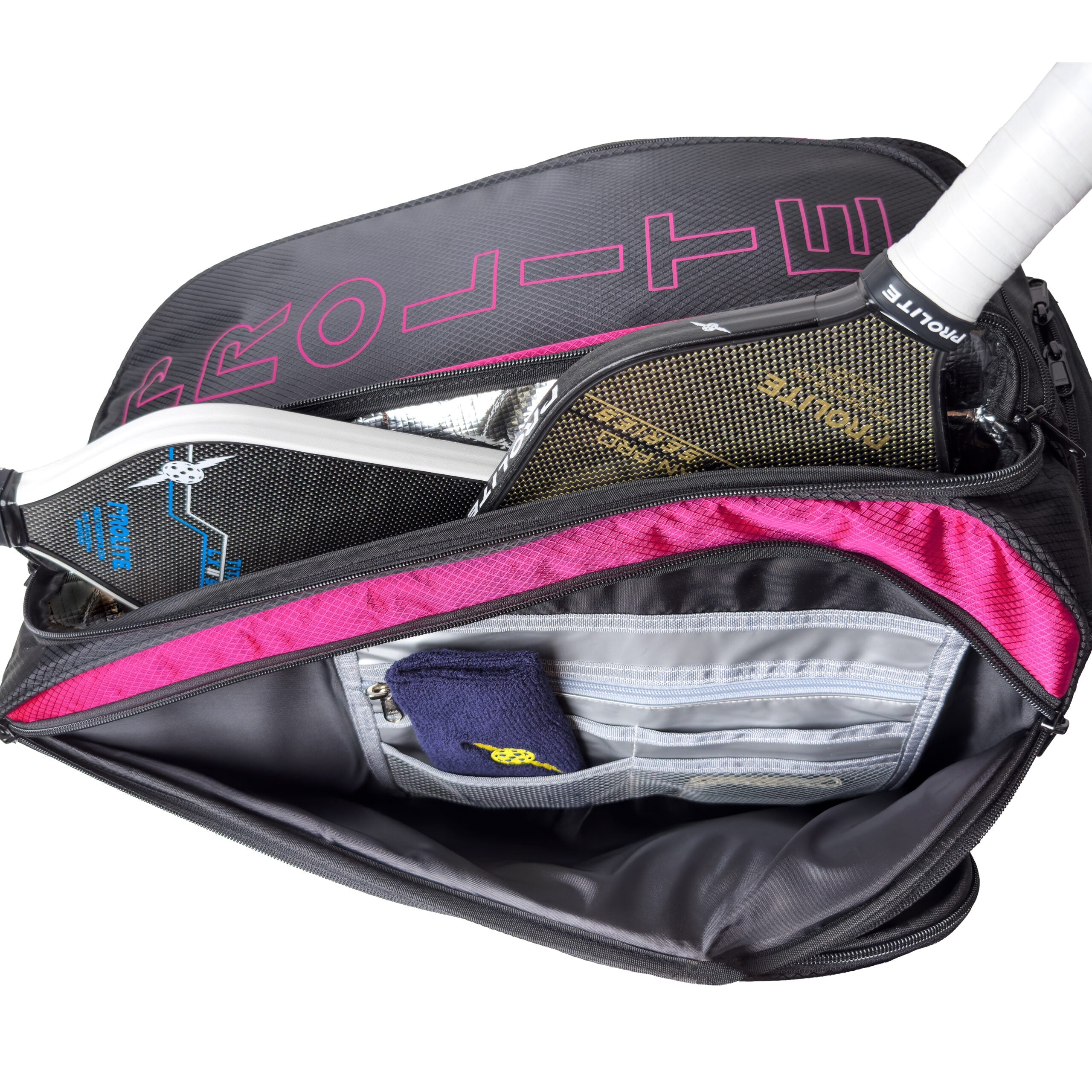 Open pickleball bag with paddle, towel, and multiple zippered pockets.