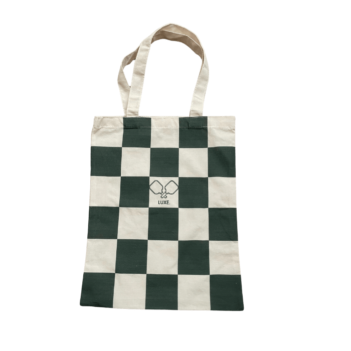 Checkered tote bag with handles and logo.