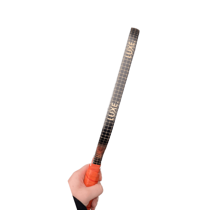 Hand holding a "LUXE" branded black and gold paddle.