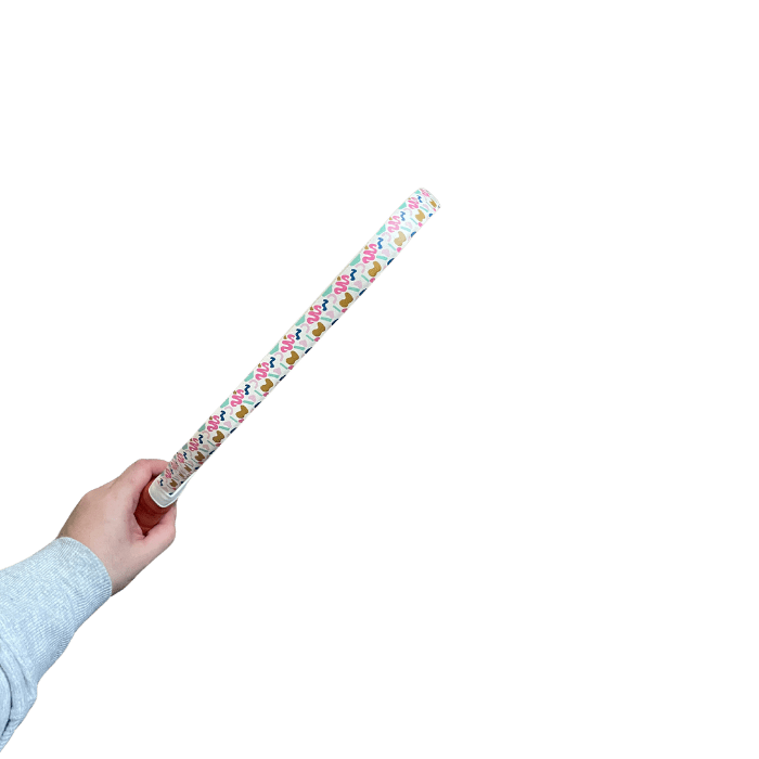 A hand holding a patterned rolling pin.