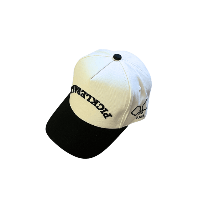 White and black baseball cap with "PICKLEBALL" embroidered on the front and "LUXE" on the side.