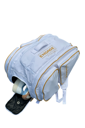 White and gold Pro Team Bag by EngagePickleball, angled with a shoe compartment open revealing light blue and brown shoes.