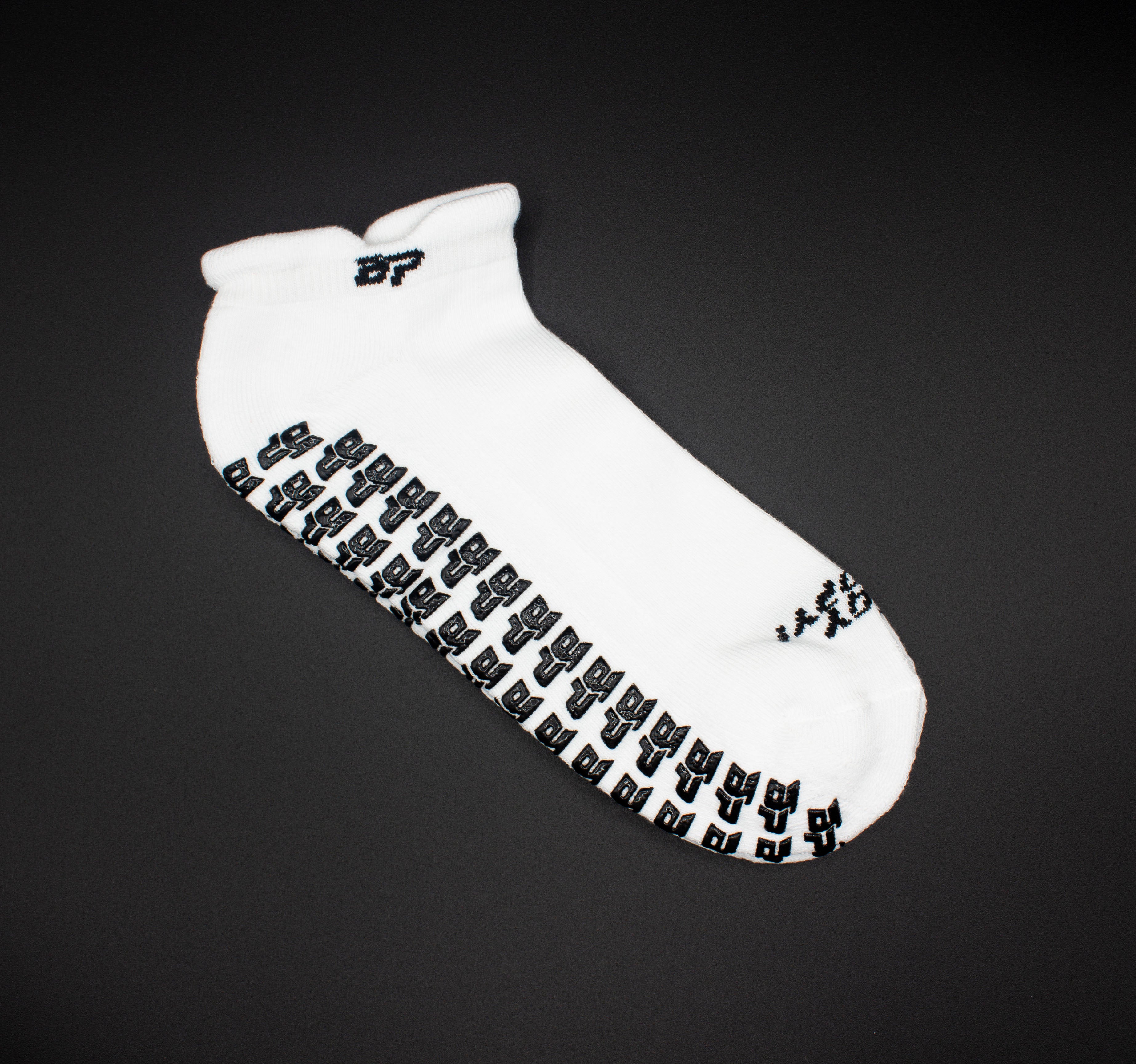 White unisex performance socks by Bodhi Performance, featuring a black grip pattern on the sole and logo on the cuff.