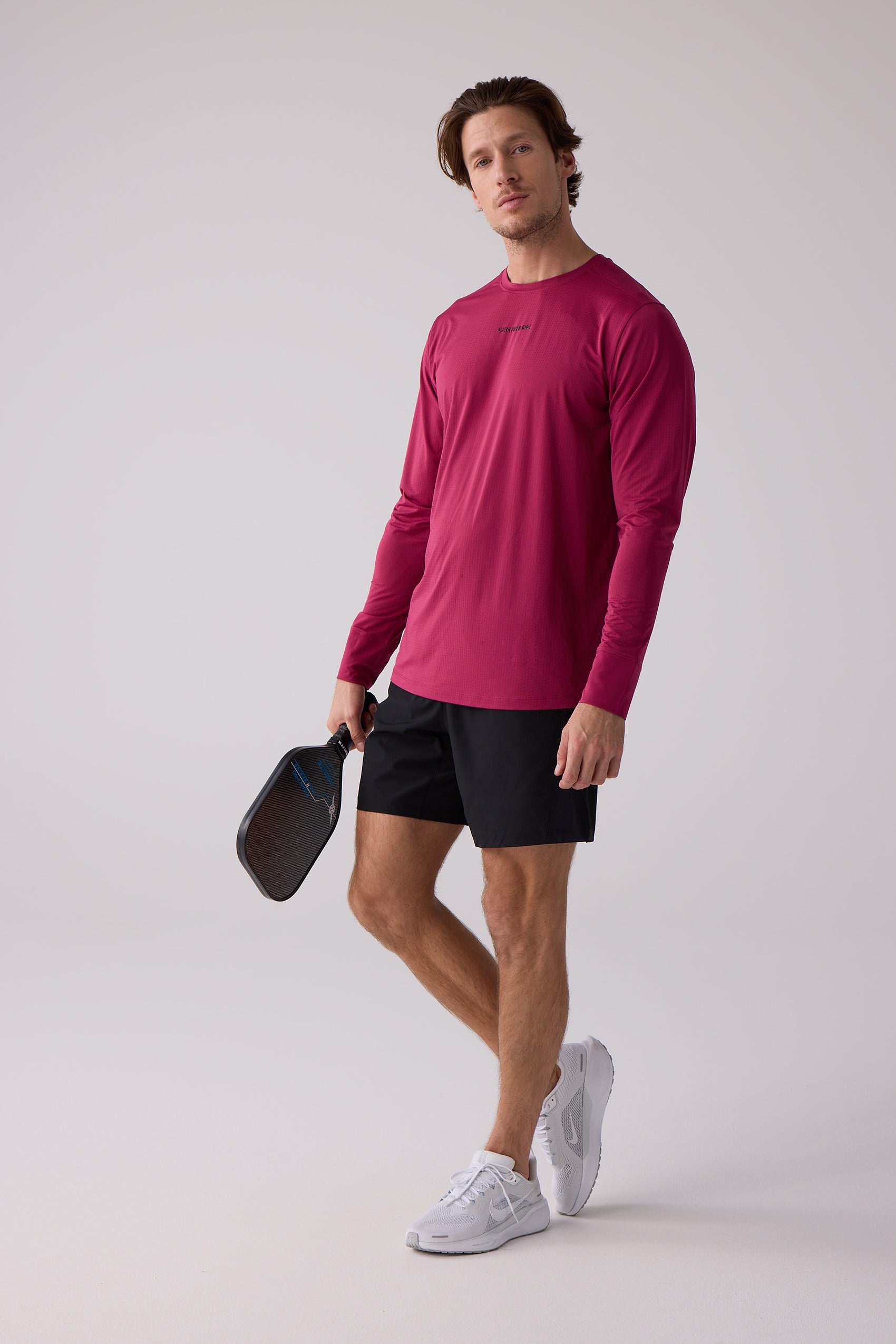 Maroon long sleeve athletic shirt by Centerline Athletics with textured fabric, worn by a man in black shorts and white shoes holding a pickleball paddle.