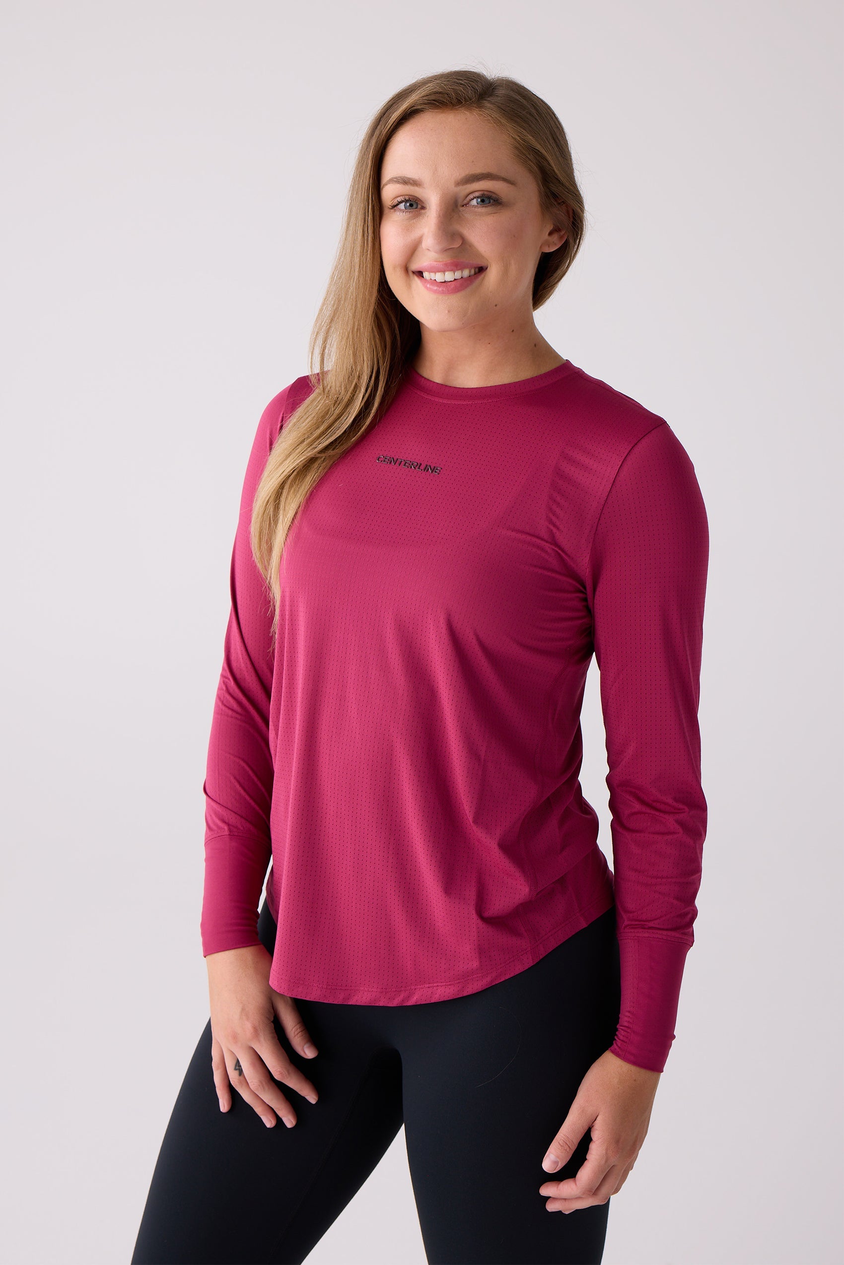 Fuchsia micro-perforated women's long sleeve shirt by Centerline Athletics, featuring "CENTERLINE" text on the chest, worn with black leggings.
