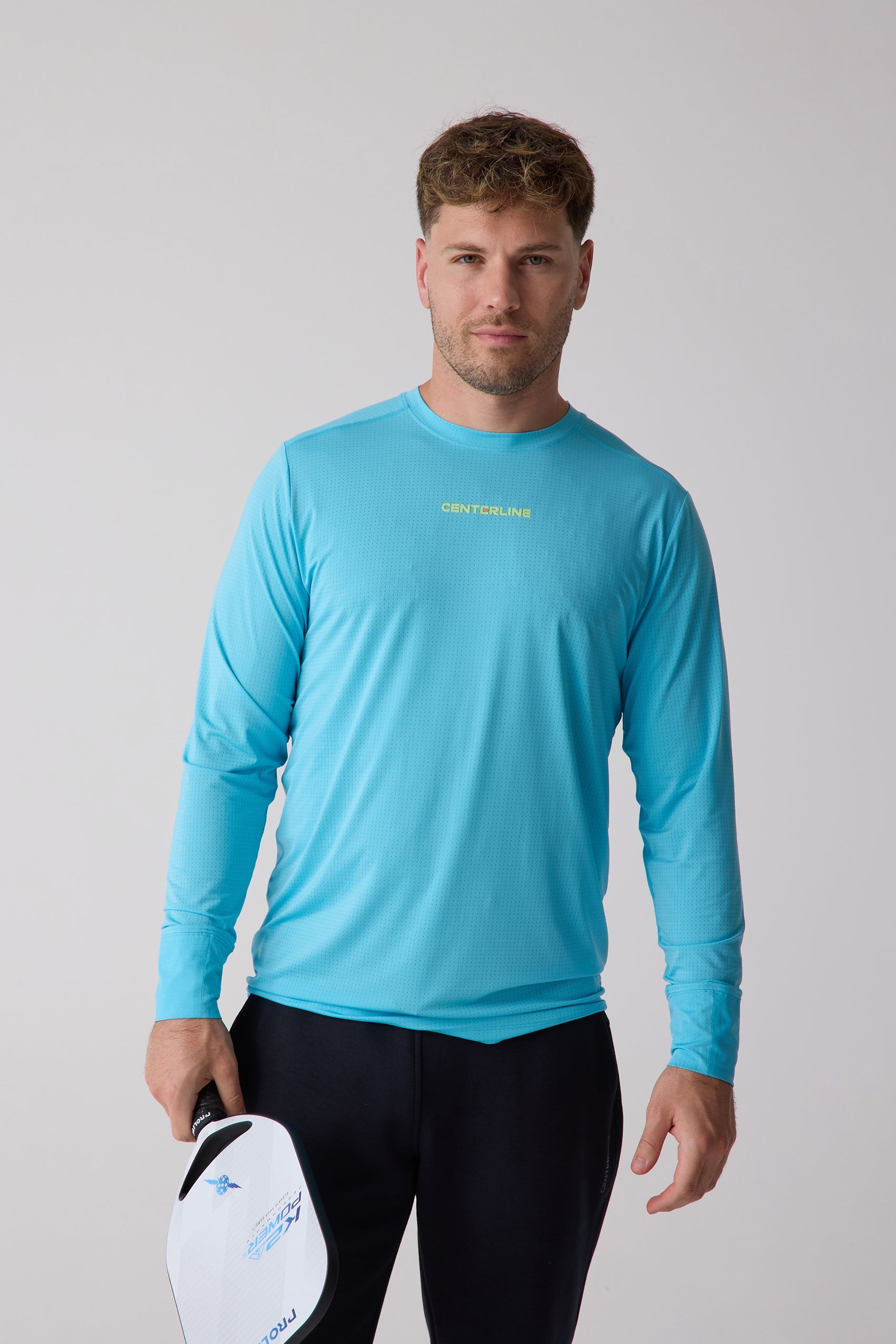 Bright blue men's long sleeve shirt by Centerline Athletics, with a perforated texture and yellow chest logo.
