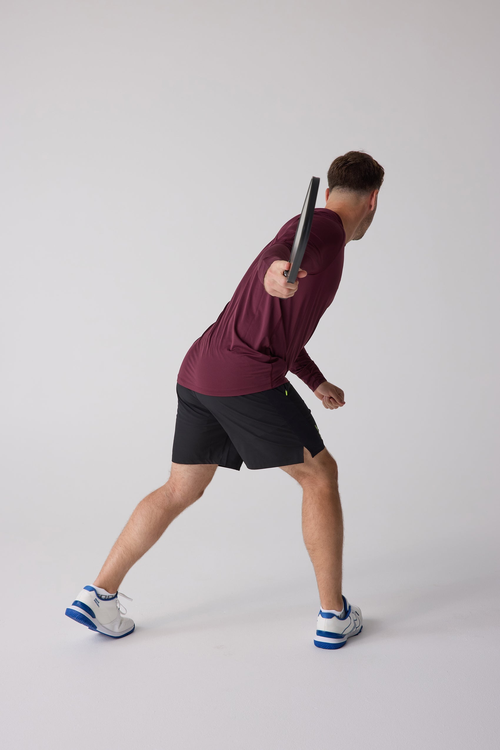 Men's AirLite long sleeve shirt in maroon by Centerline Athletics, with textured fabric, shown in a rear view worn by a man holding a paddle.