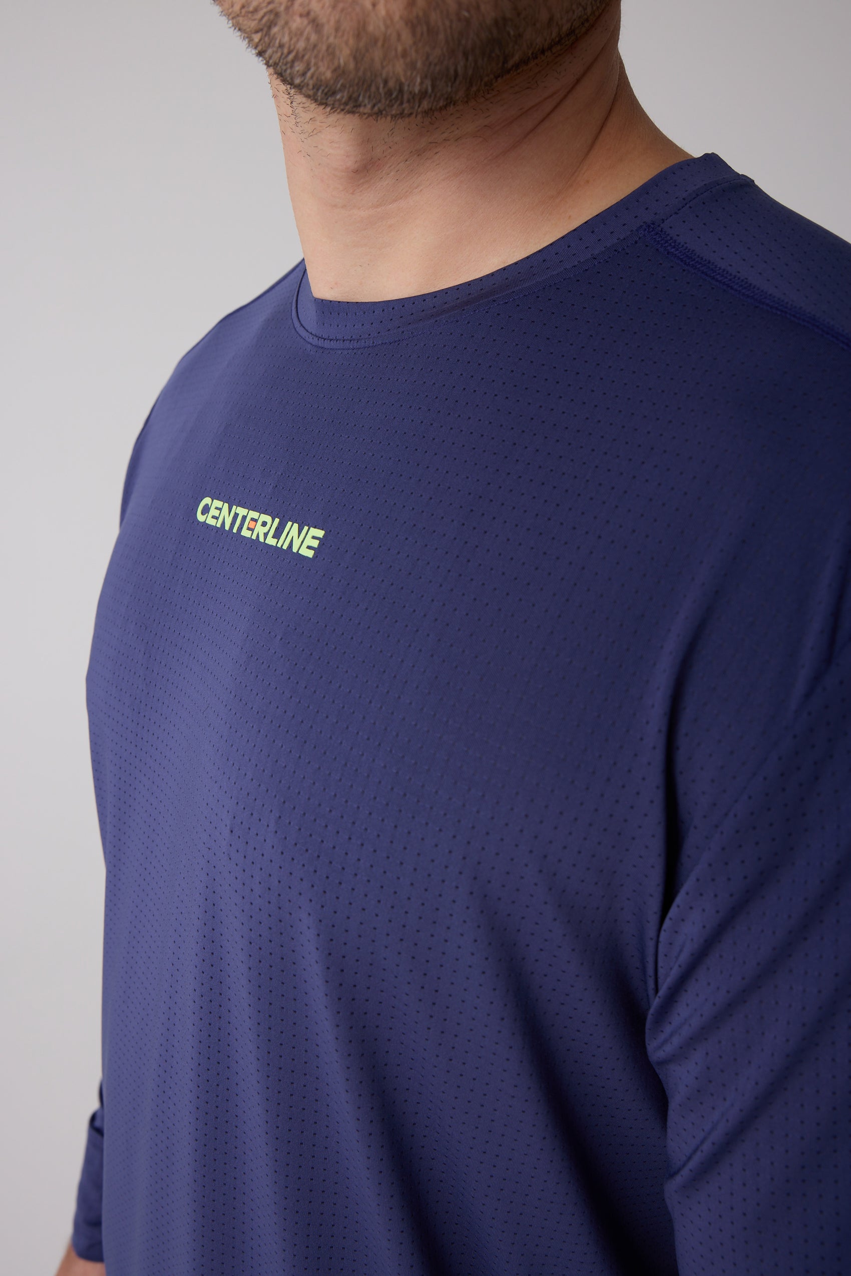 Navy blue AirLite long sleeve shirt by Centerline Athletics, with a perforated texture and bright yellow-green 'CENTERLINE' logo on the chest.