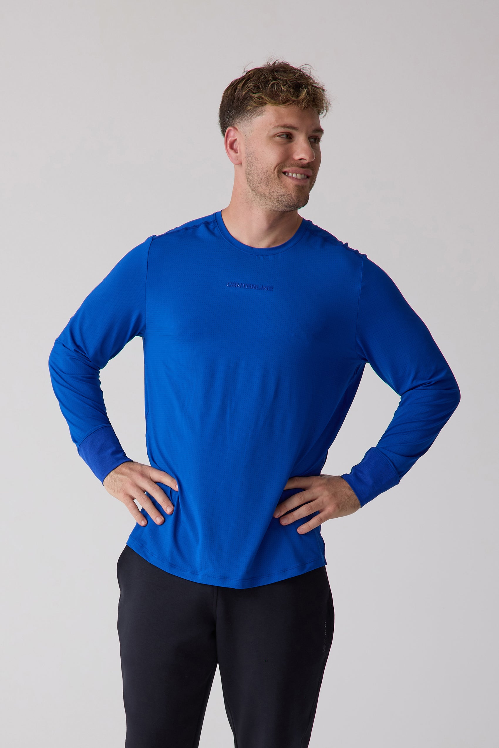 Blue textured Men's AirLite Long Sleeve by Centerline Athletics with subtle chest logo, worn with black athletic pants.