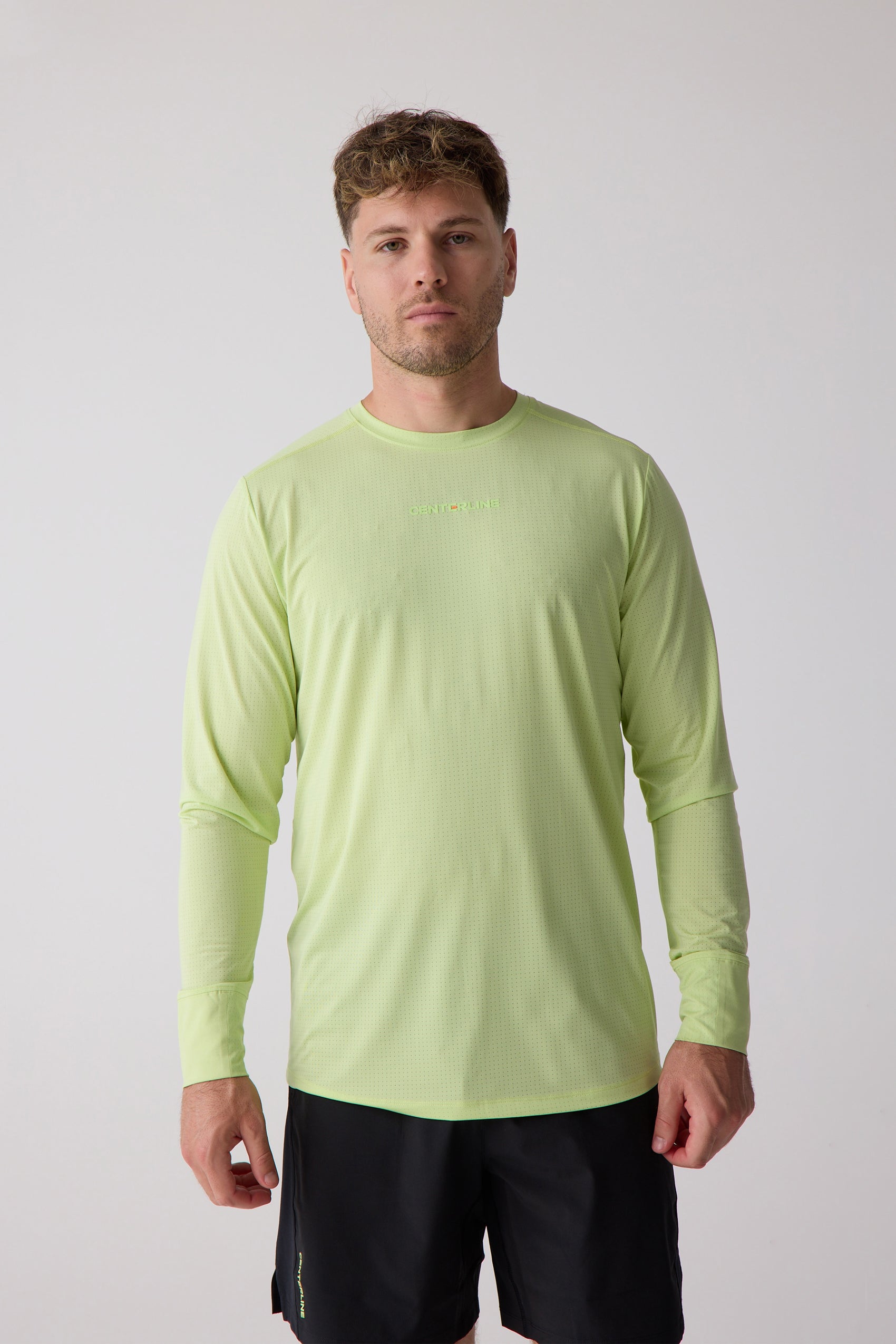 Men's lime green long sleeve shirt by Centerline Athletics, with perforated texture and "CENTERLINE" text, worn with black shorts.