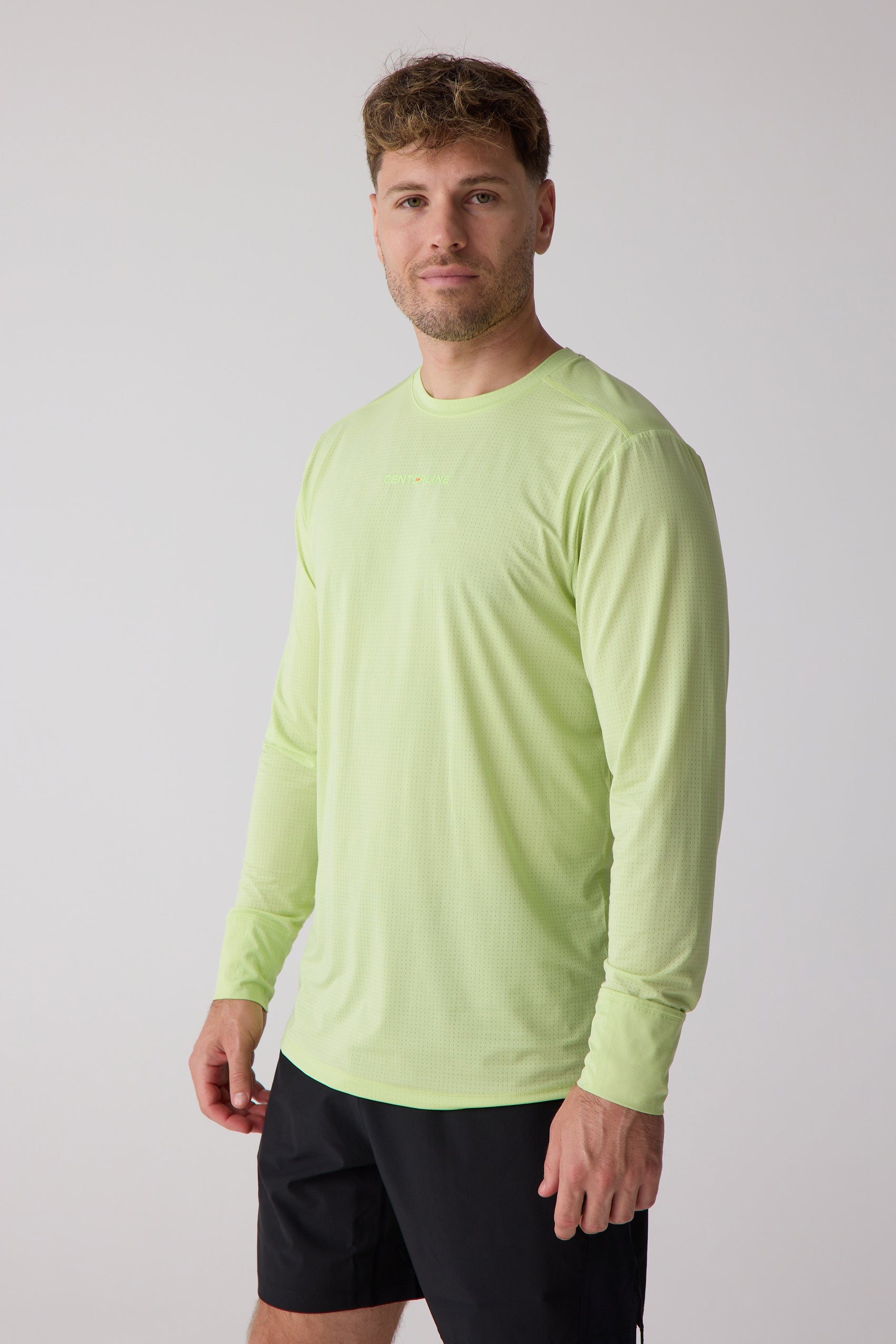 Light green long sleeve shirt from Centerline Athletics with a perforated texture and subtle chest logo, worn by a man in black shorts.