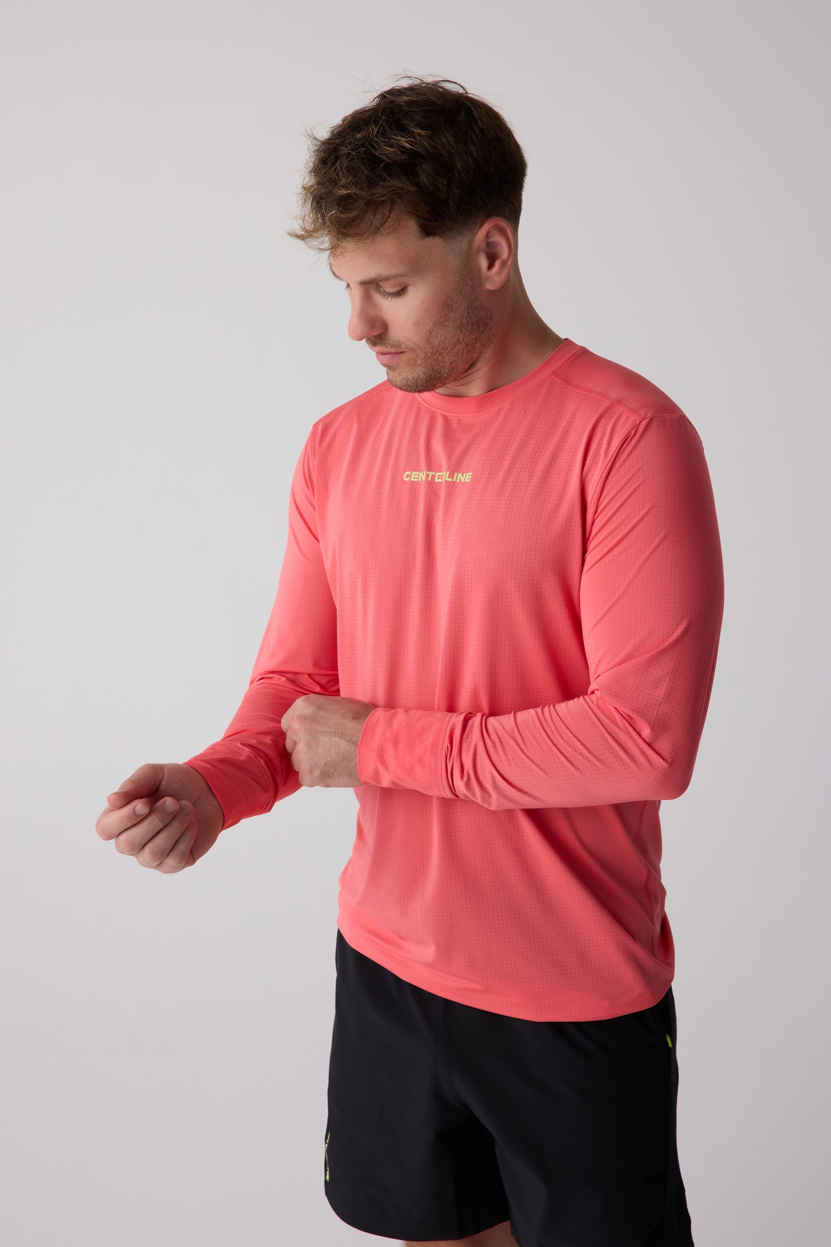 Coral pink perforated men's long sleeve shirt by Centerline Athletics, with "CENTERLINE" text on chest.