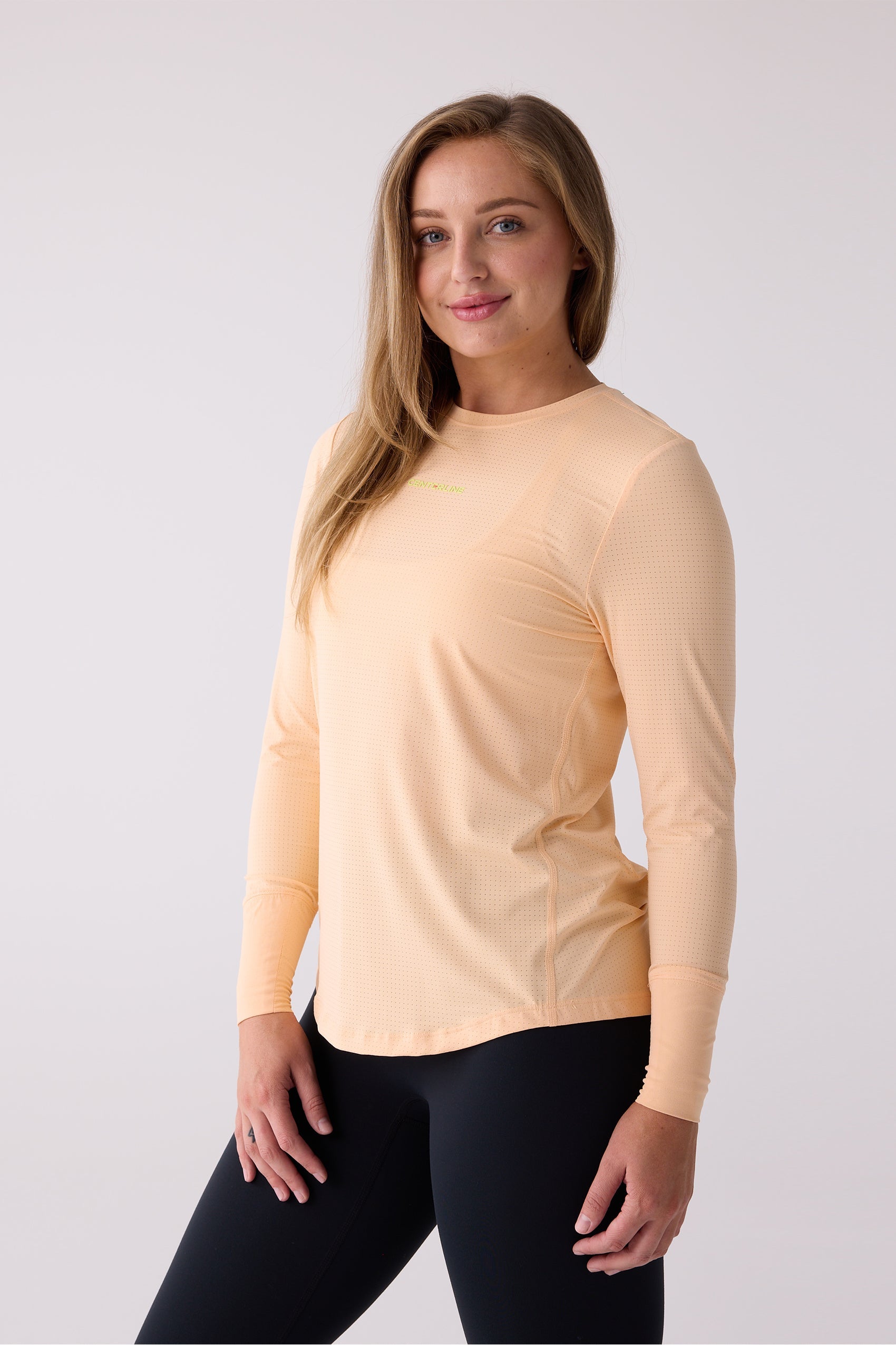Perforated peach long sleeve shirt by Centerline Athletics, with "CENTERLINE" text on the chest, worn with black leggings.