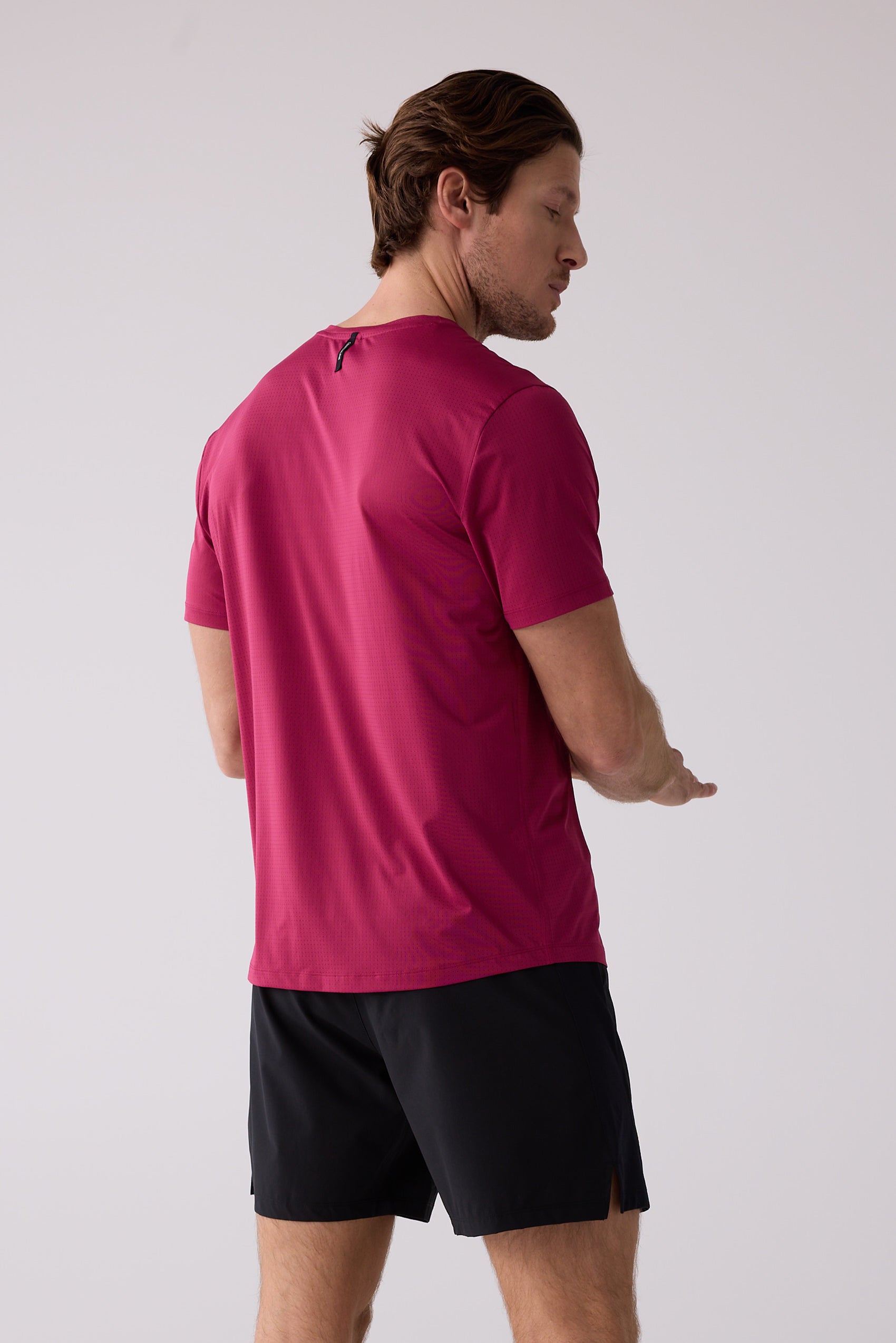 Men's magenta AirLite tee by Centerline Athletics with micro-perforated texture and black neck loop.