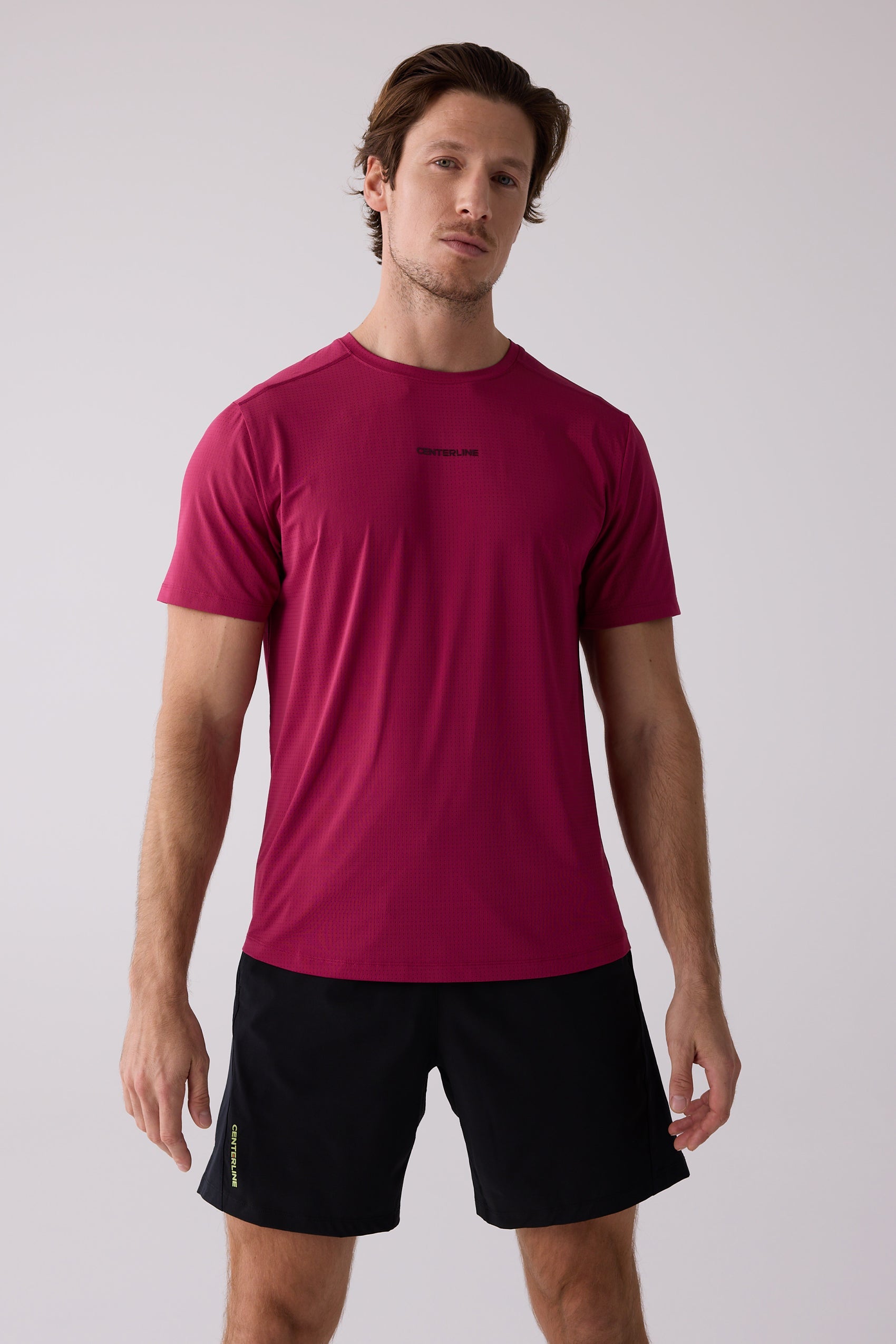 Maroon men's short-sleeve tee by Centerline Athletics, featuring a perforated texture and chest logo, worn with black shorts.