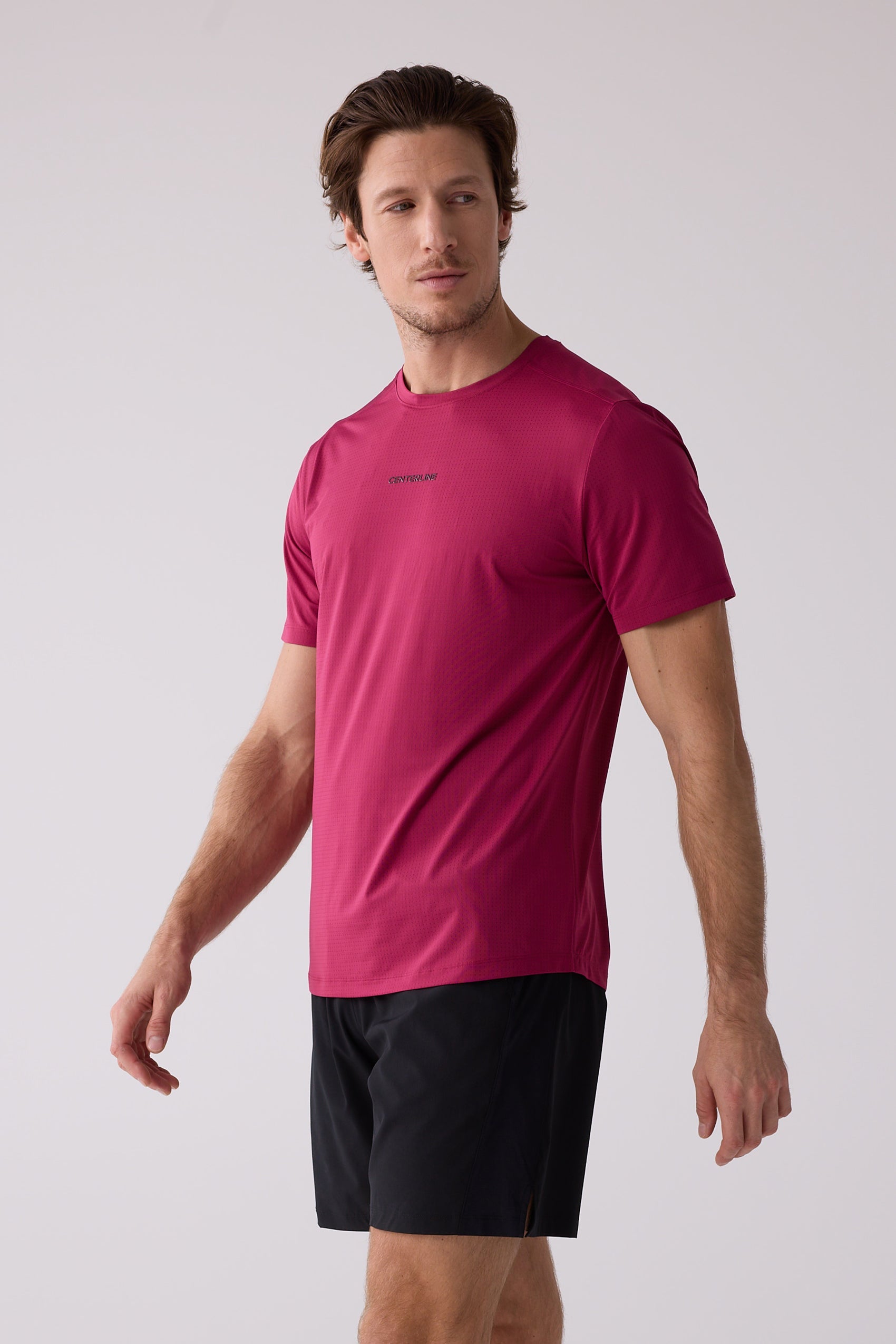 Maroon Men's AirLite Tee by Centerline Athletics, with perforated fabric and "CENTERLINE" text, worn with black shorts.