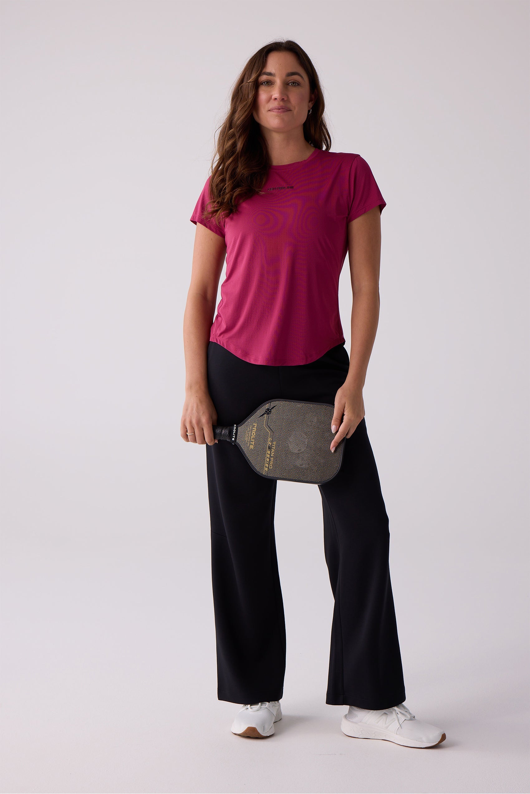 Magenta Women's Airlite short sleeve tee by Centerline Athletics with a perforated texture and curved hem.