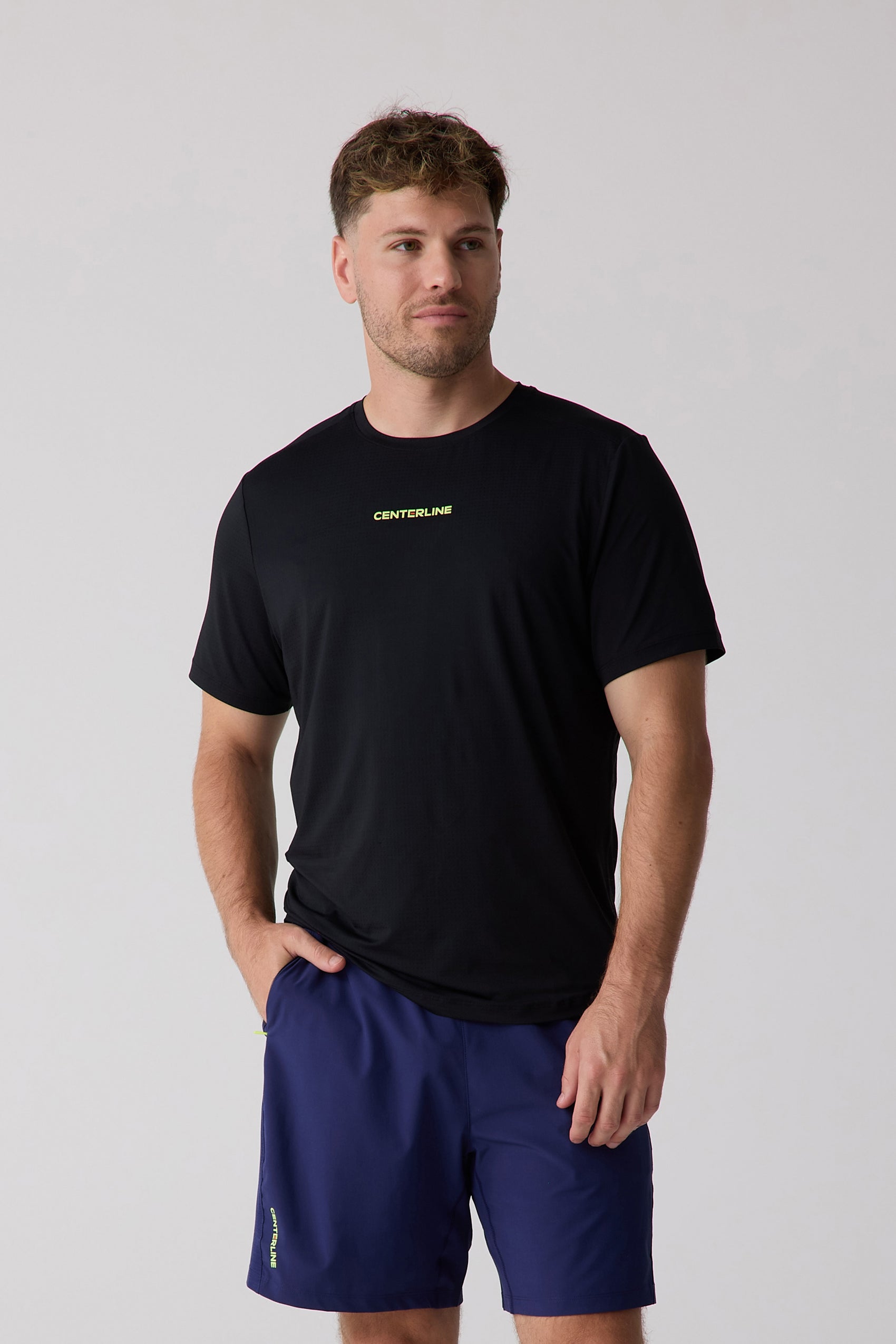 Black men's tee with subtle grid texture by Centerline Athletics, featuring a neon yellow-green 'CENTERLINE' logo on the chest.